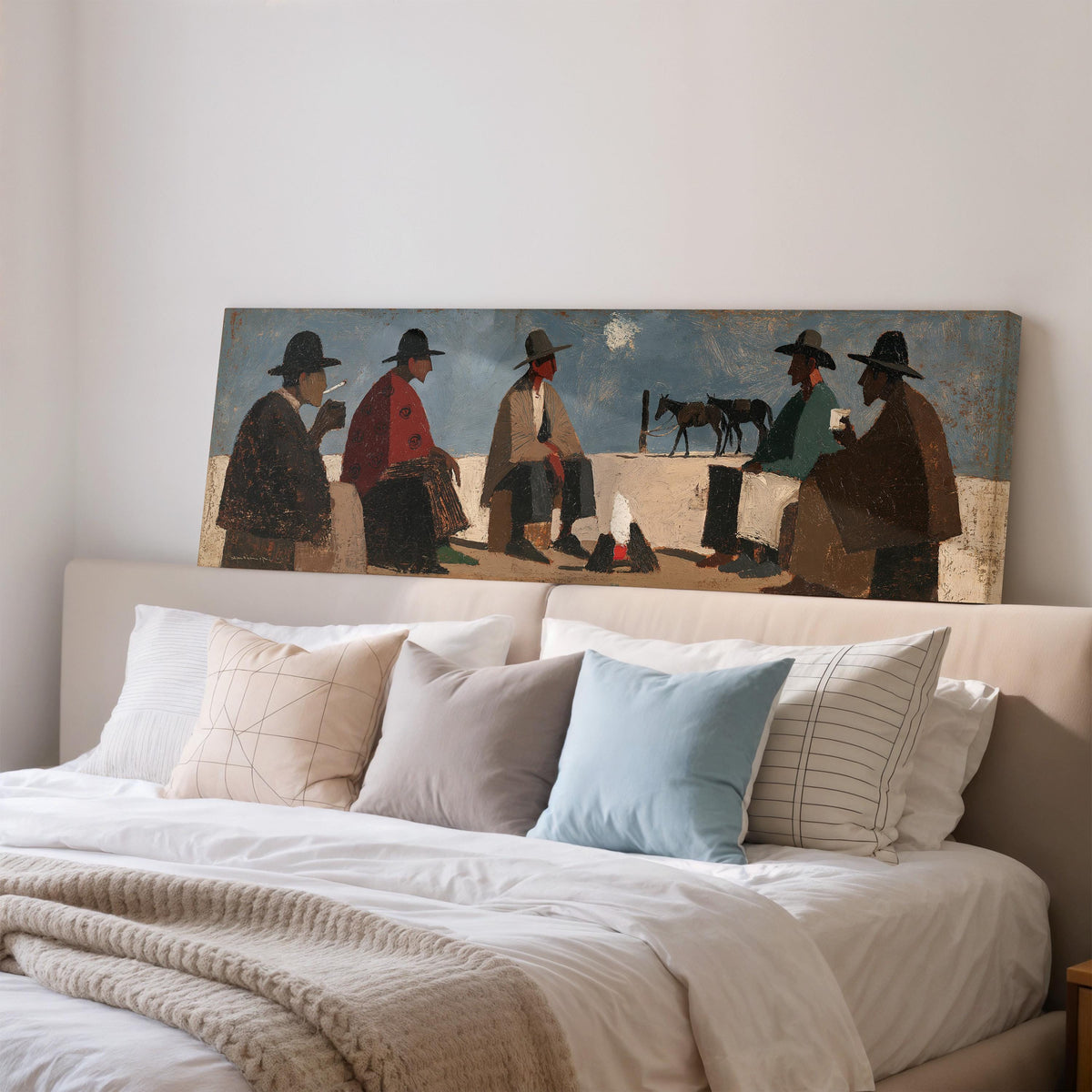 Cowboys gathered around a campfire wide panoramic canvas print above a bed in a bedroom