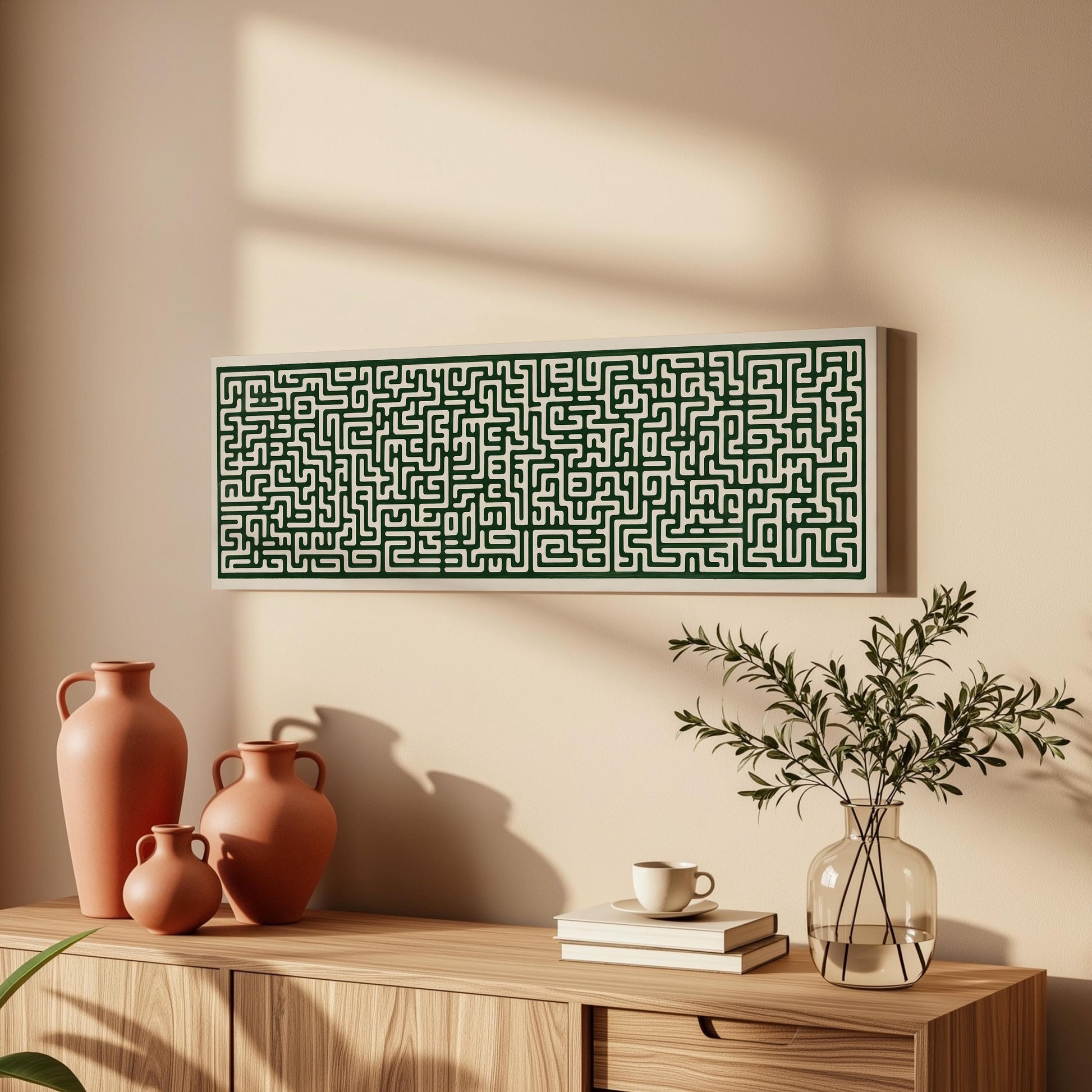a wooden cabinet with a large green maze-like artwork hanging on the wall above it. The cabinet also has three orange vases and a glass vase with greenery on top.