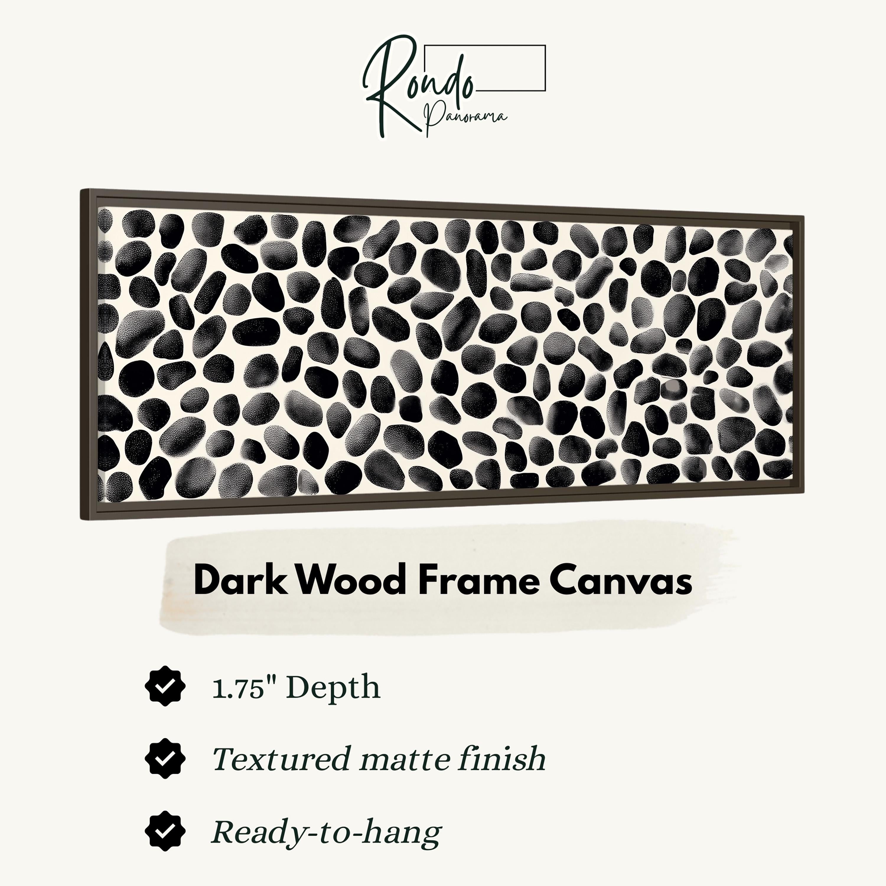 a dark wood frame canvas with a black and white speckled pattern.