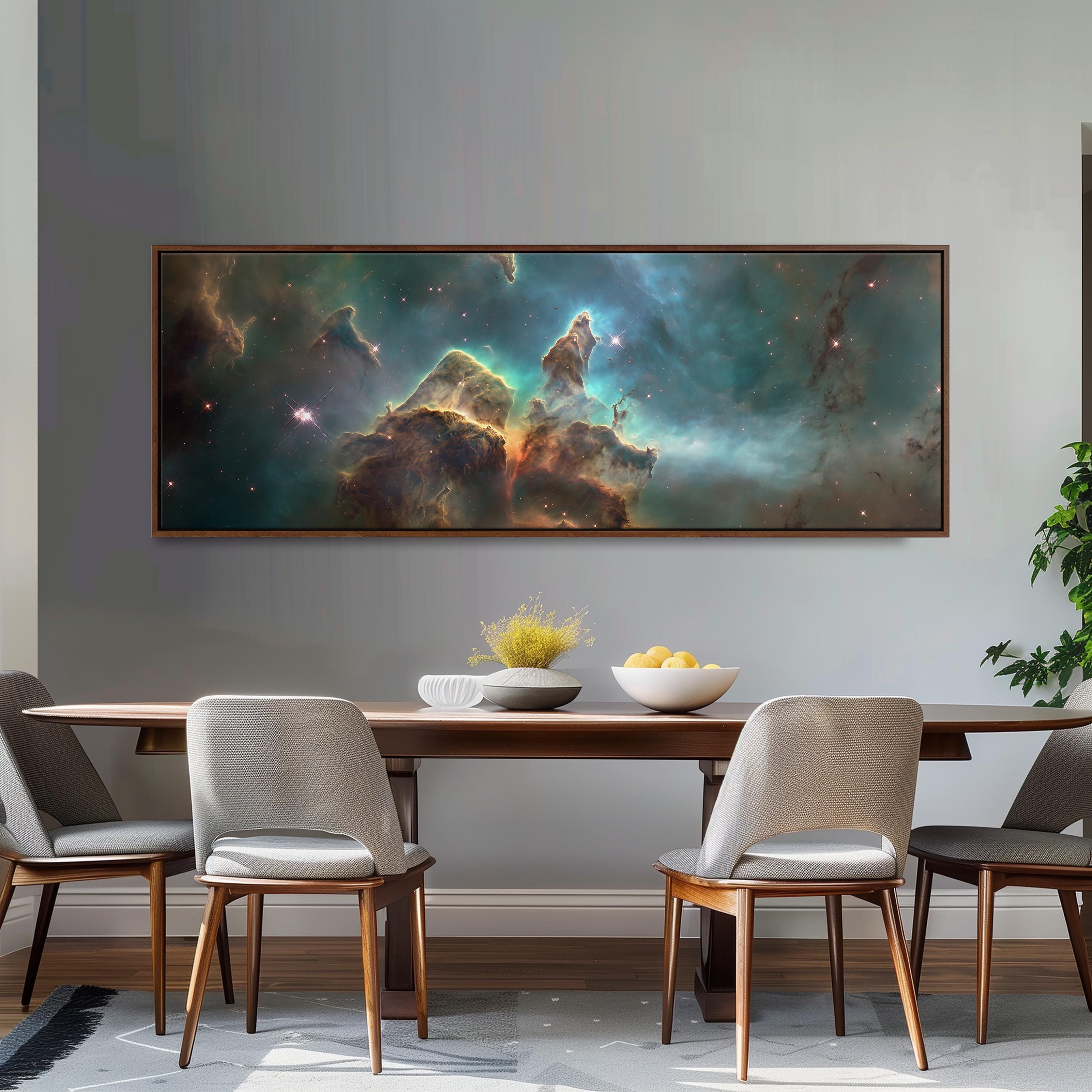 a large, framed painting of a nebula hanging on a wall above a wooden dining table with four chairs. The painting depicts a vibrant, colorful nebula with swirling clouds of gas and dust.