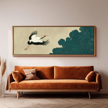 a large, framed artwork of a crane in flight above a brown sofa in a living room setting.