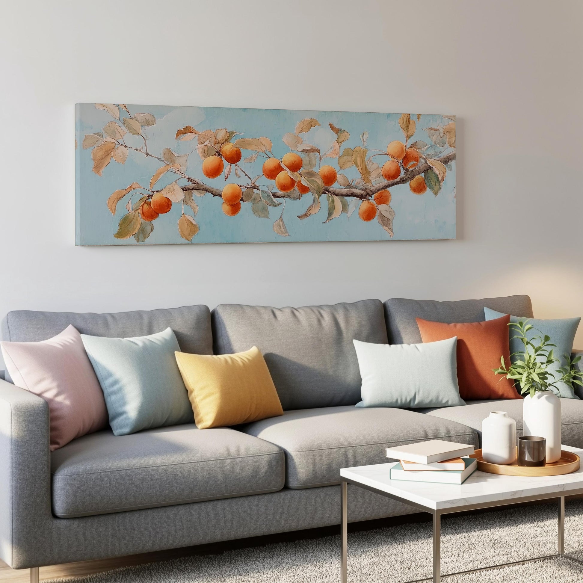 a gray couch with colorful throw pillows, a white coffee table, and a painting of a tree branch with orange fruits hanging from it.