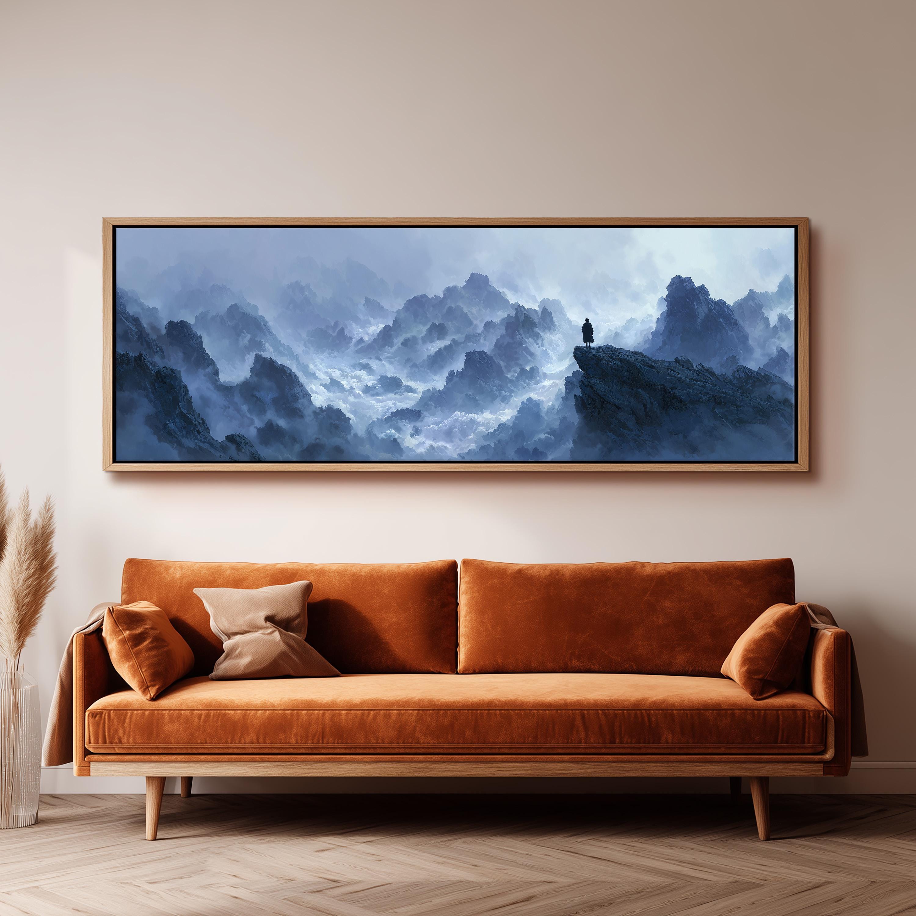 a large, framed painting of a mountainous landscape hanging on a wall above a brown sofa.