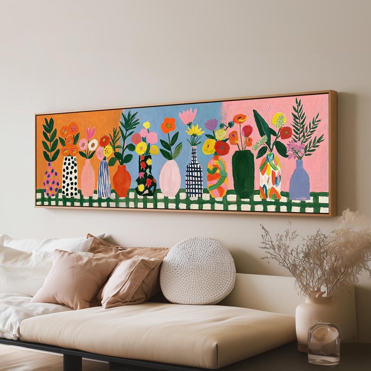 Folk art flower vases on orange and blue long horizontal canvas print above a sofa in a living room