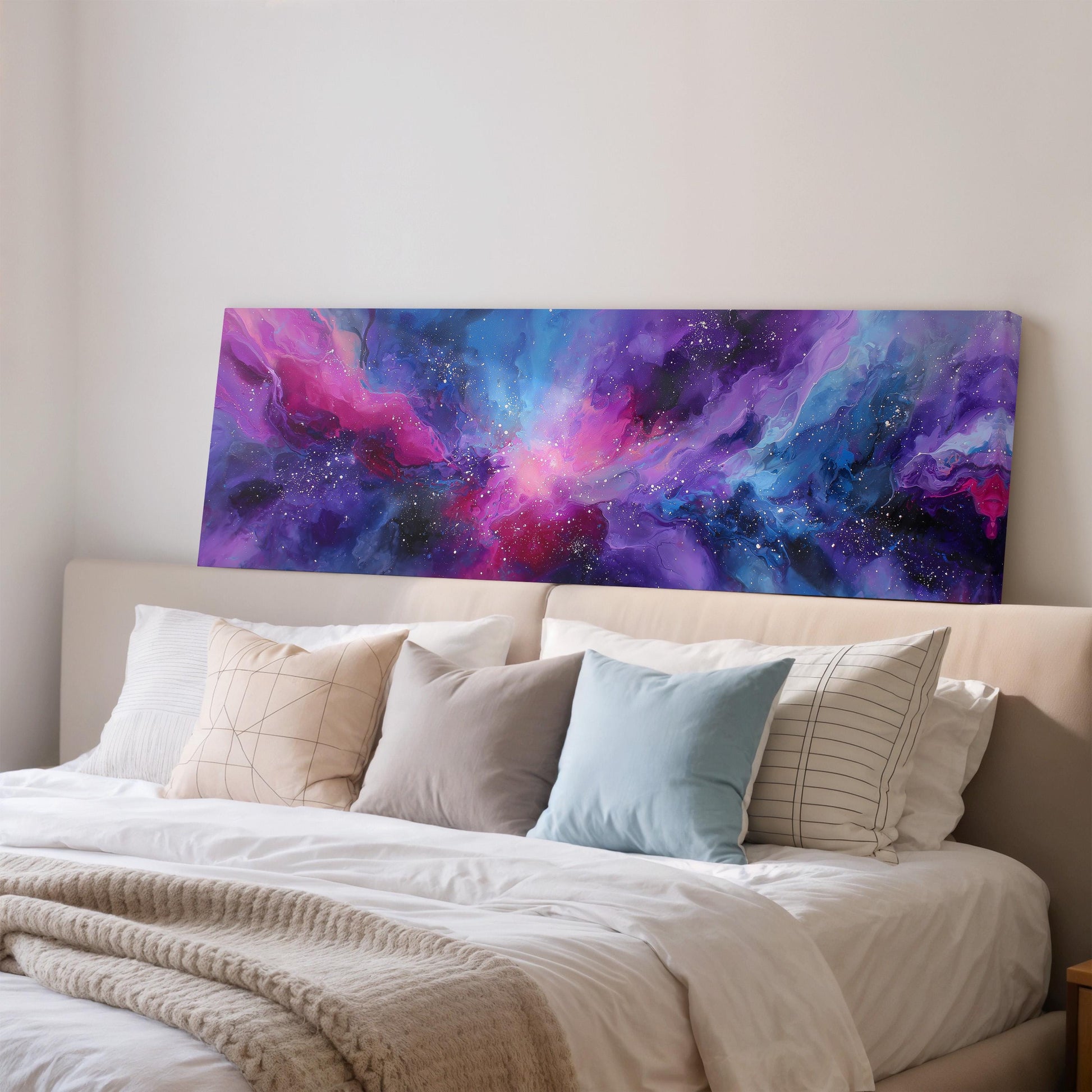 a large, colorful abstract painting hanging on a wall above a bed with white bedding and pillows.