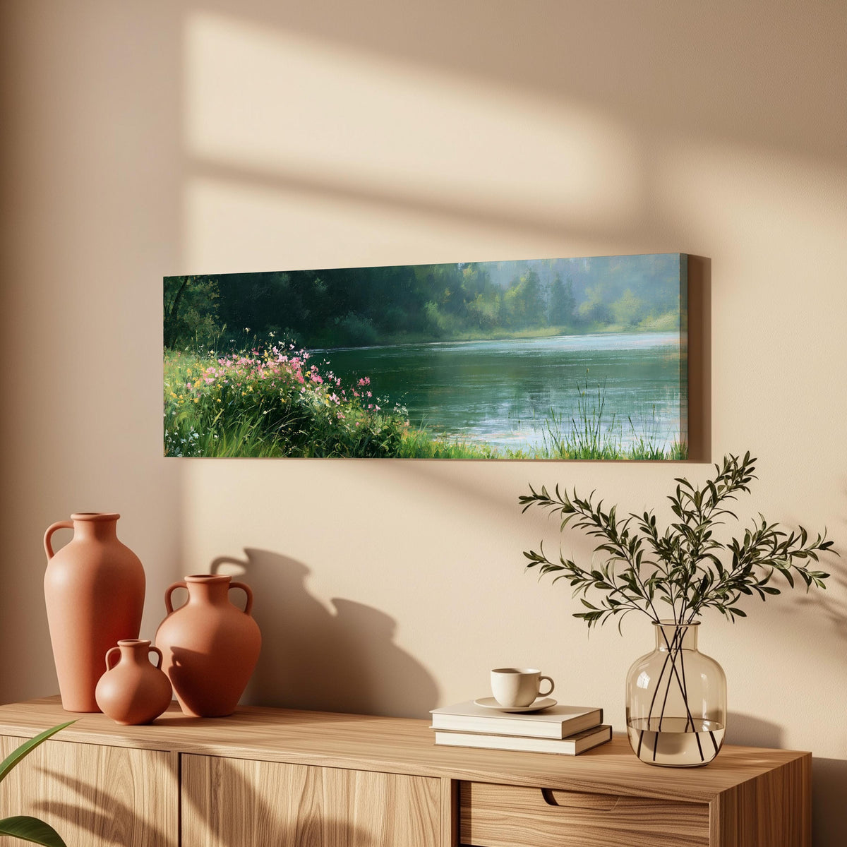 Pink wildflowers on a green lakeshore long horizontal canvas print above a wooden sideboard