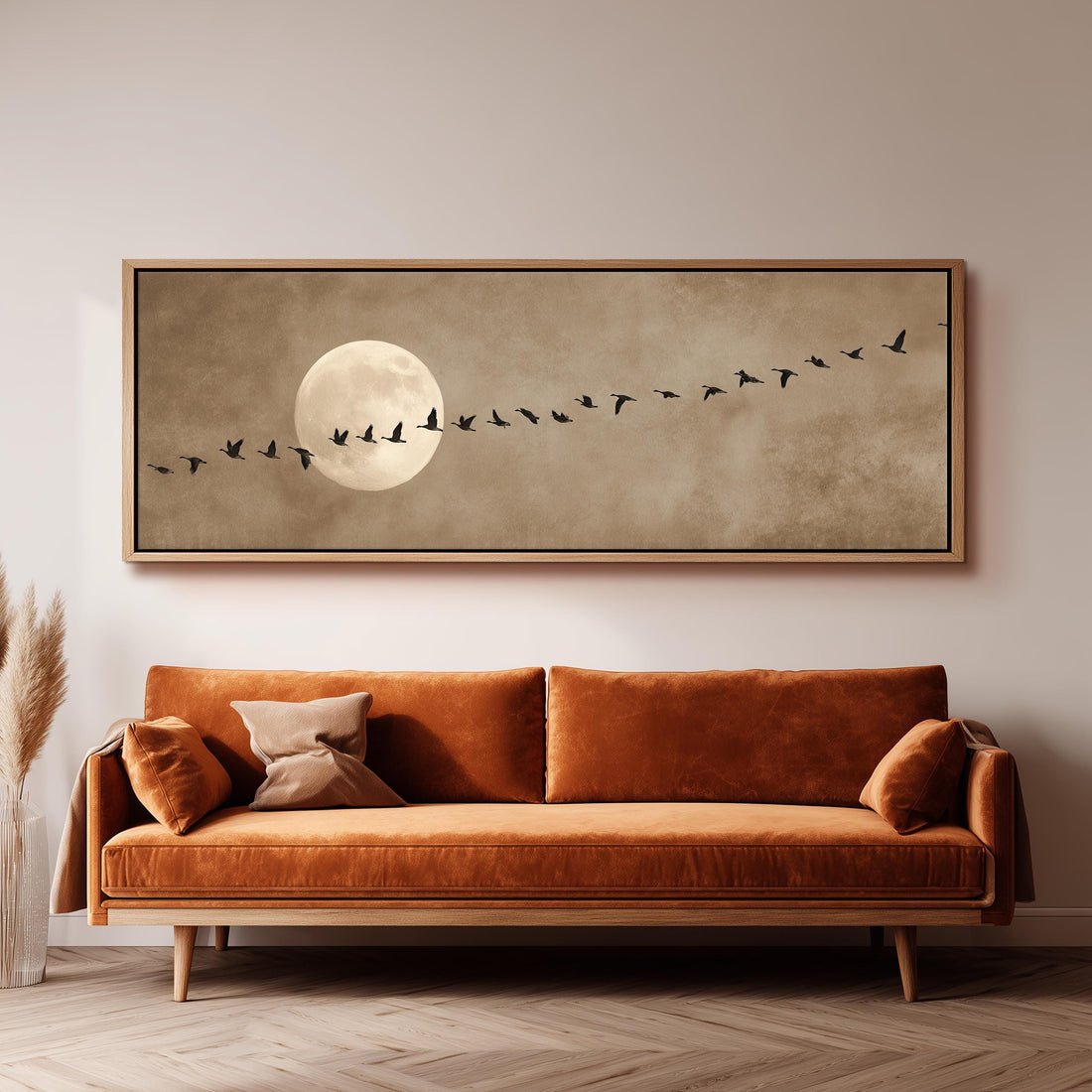a large framed artwork depicting a flock of birds flying in formation, with a full moon in the background.