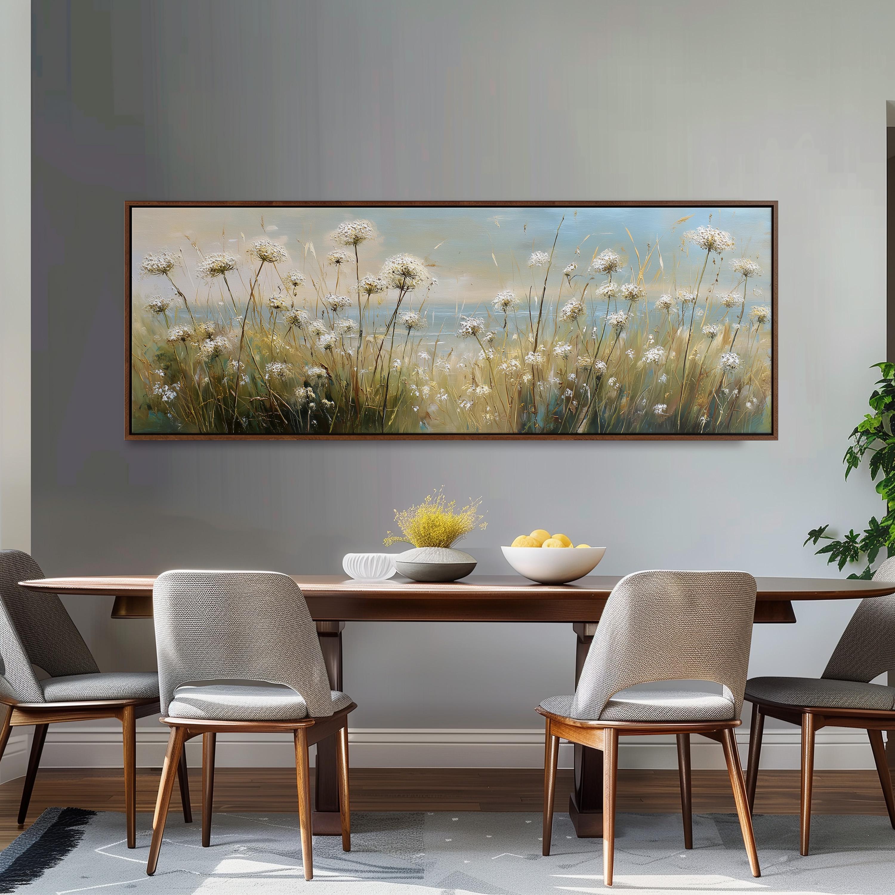 a dining room with a large painting of a field of flowers hanging on the wall above a wooden dining table with four chairs. The table is set with a bowl of fruit and a vase of flowers, creating a cozy and inviting atmosphere.