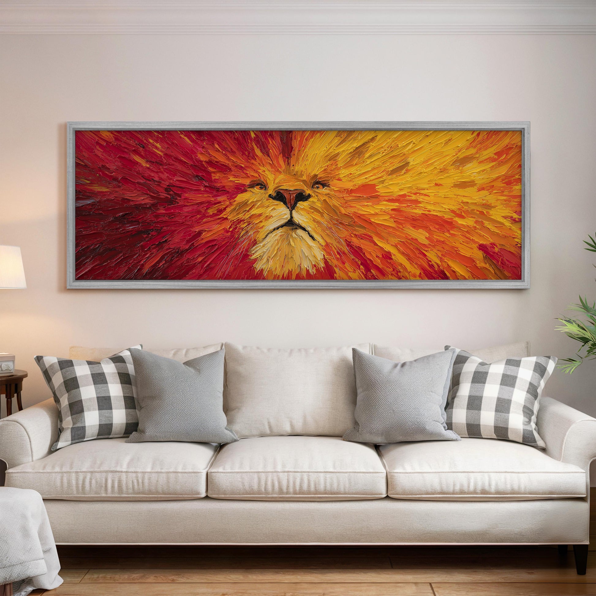 a large, vibrant painting of a lion's face hanging on a wall above a white couch with gray and white plaid throw pillows.