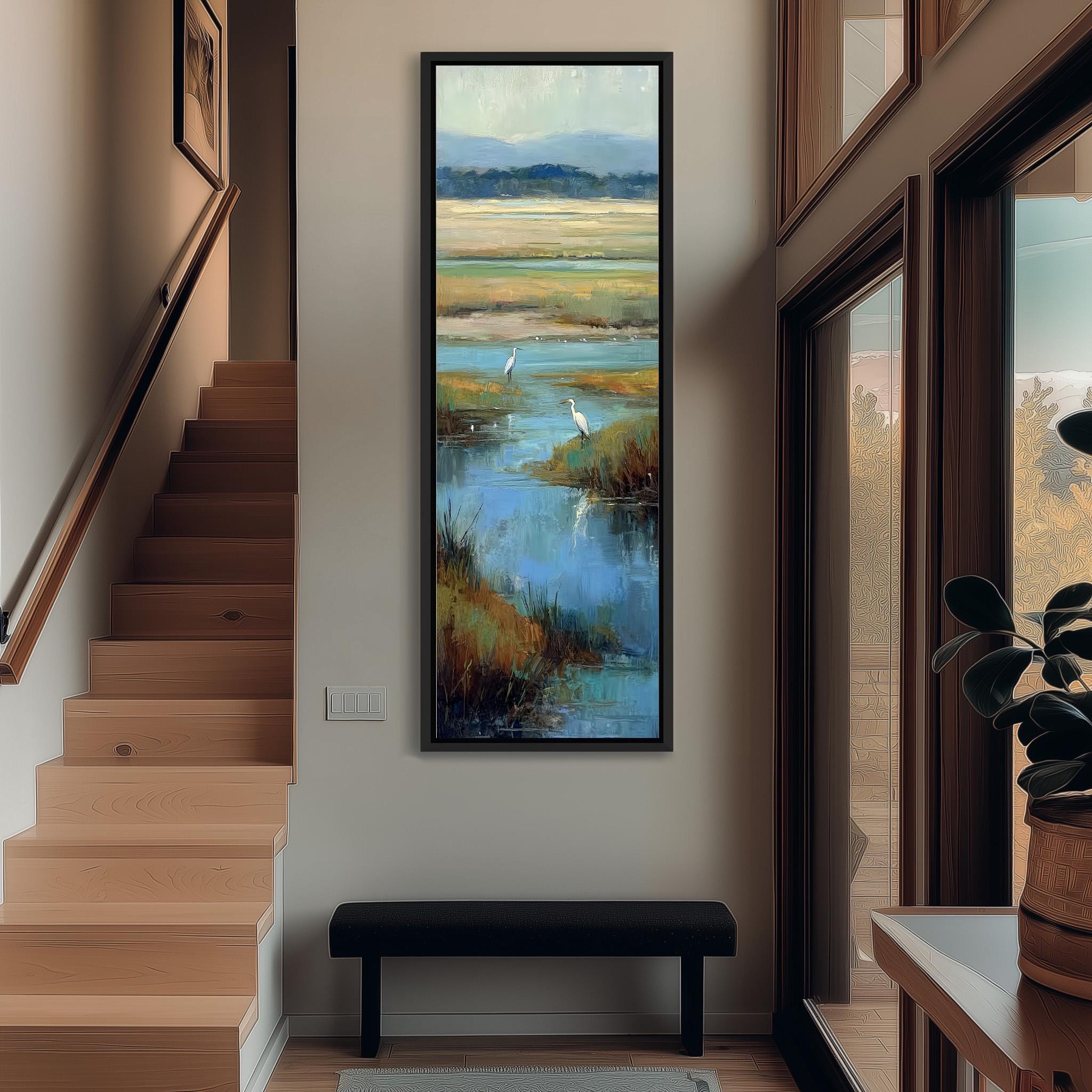 a large painting of a serene landscape hanging on the wall of a hallway. The painting depicts a tranquil scene with a body of water, lush vegetation, and a bird in flight. The hallway has a wooden staircase leading up to the painting, and a bench is situated in front of the painting. The overall atmosphere of the image is calm and peaceful, with the natural elements of the painting creating a sense of serenity.