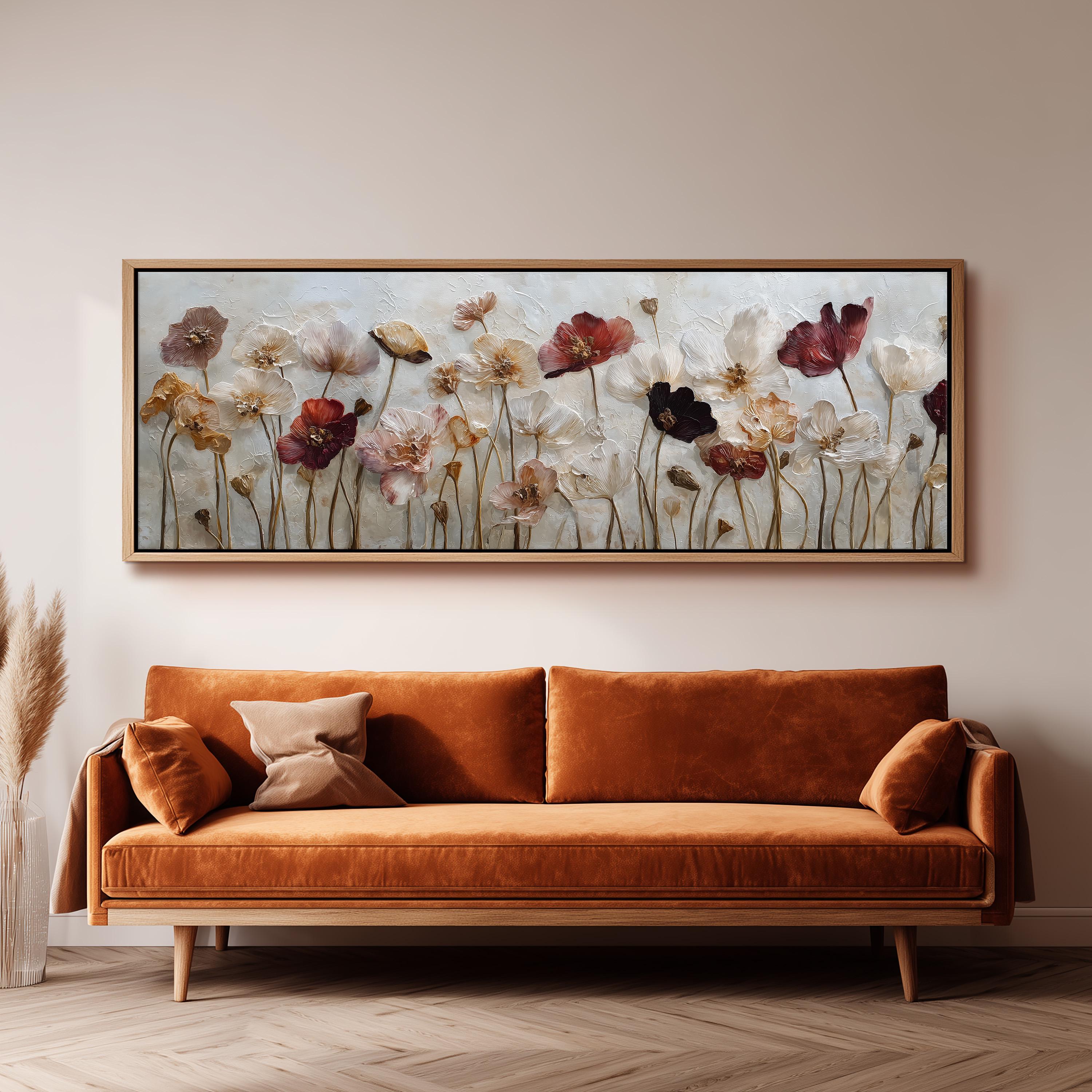 a large, framed painting of flowers hanging on a wall above a brown sofa.
