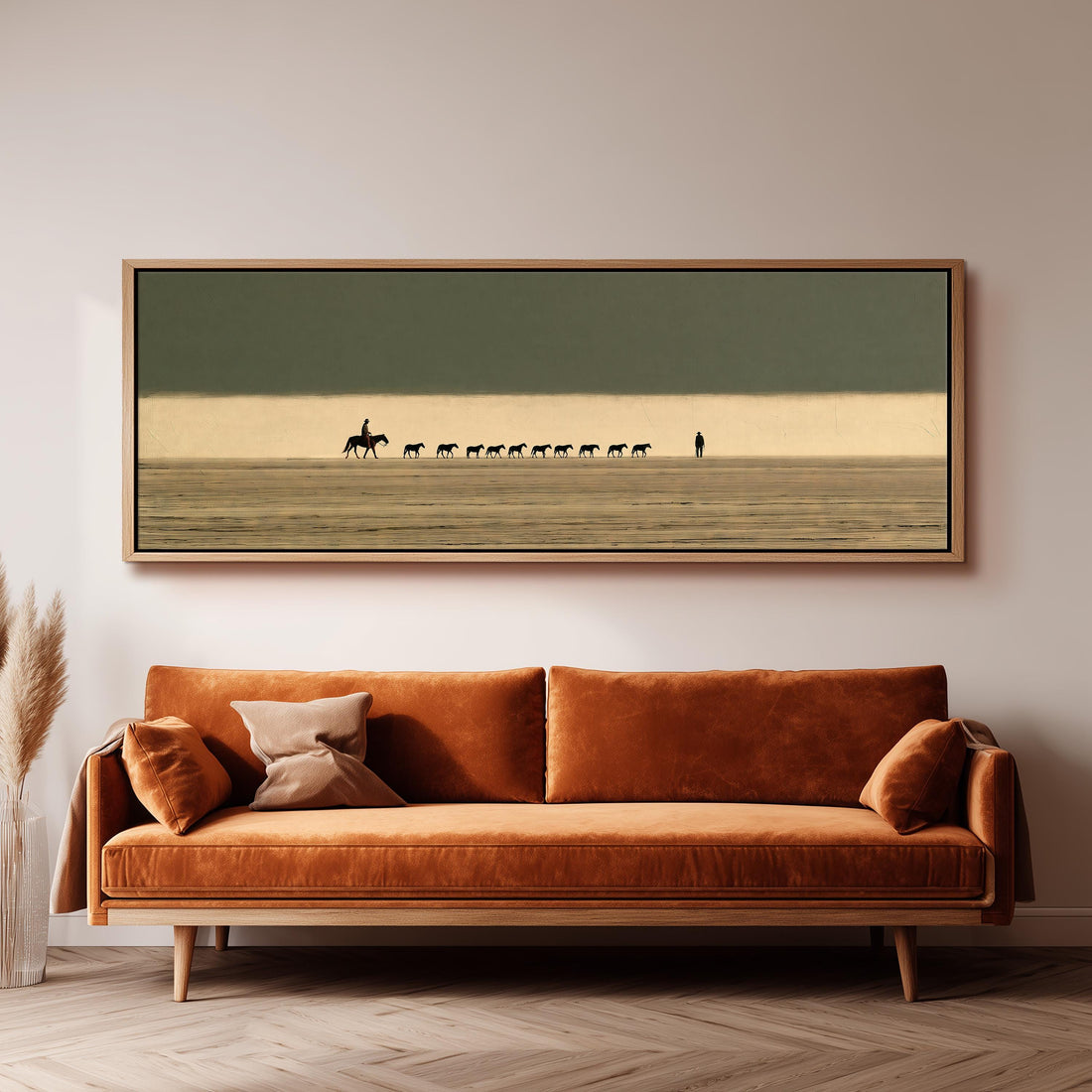 Cowboy leading a line of horses across the desert long horizontal canvas print above a sofa in a living room