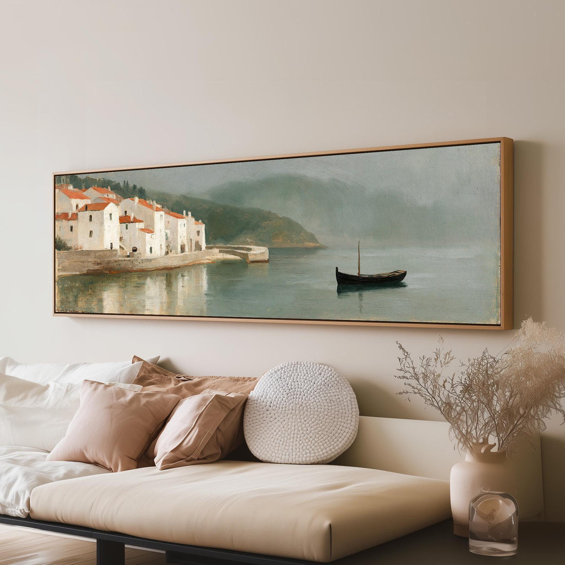 Whitewashed harbor village and a small boat long horizontal canvas print above a sofa in a living room