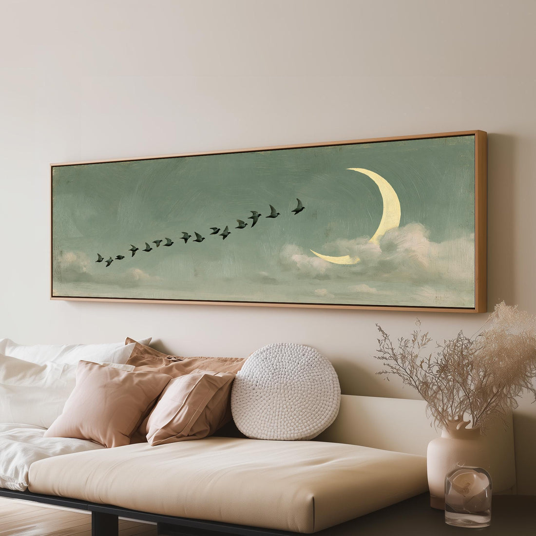 Geese flying past a crescent moon long horizontal canvas print above a sofa in a living room