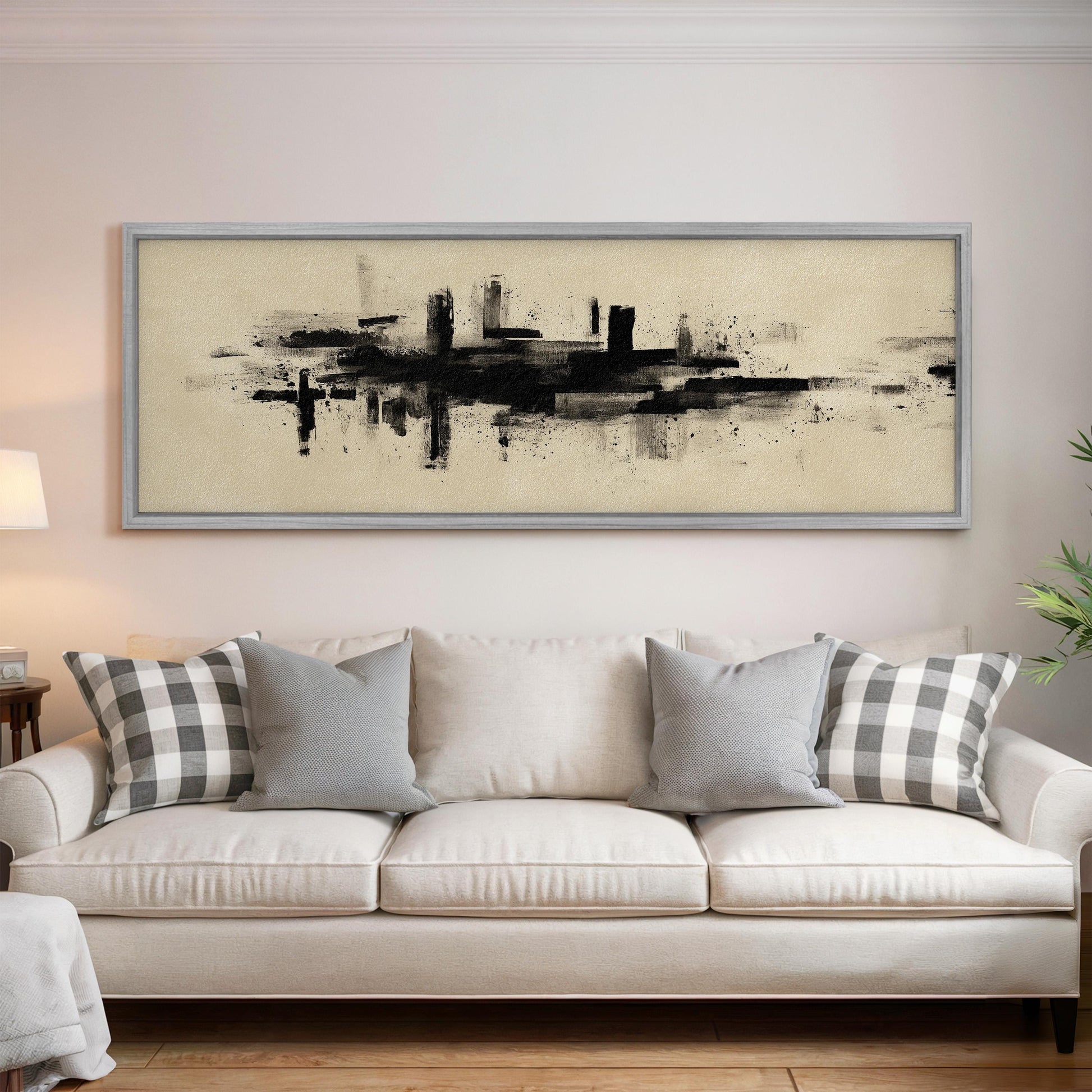 a large abstract painting hanging on a wall above a white sofa with gray and white patterned throw pillows.