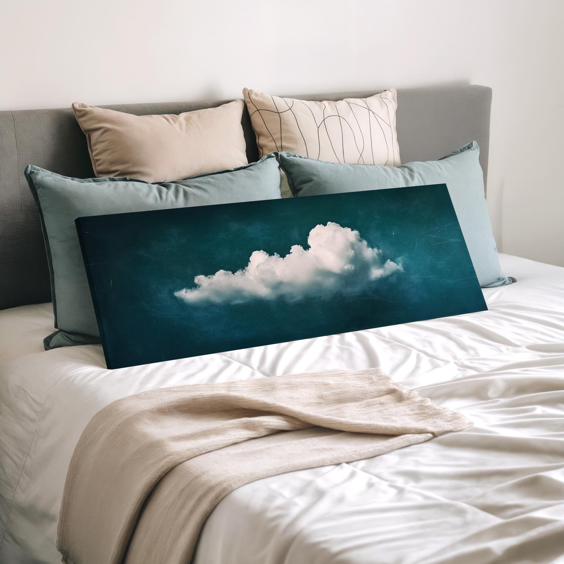 a bedroom with a bed and a large canvas print of a cloud on it. The bed is covered with white sheets and has several pillows on it. The canvas print is placed on the bed, covering a significant portion of the bed's surface.
