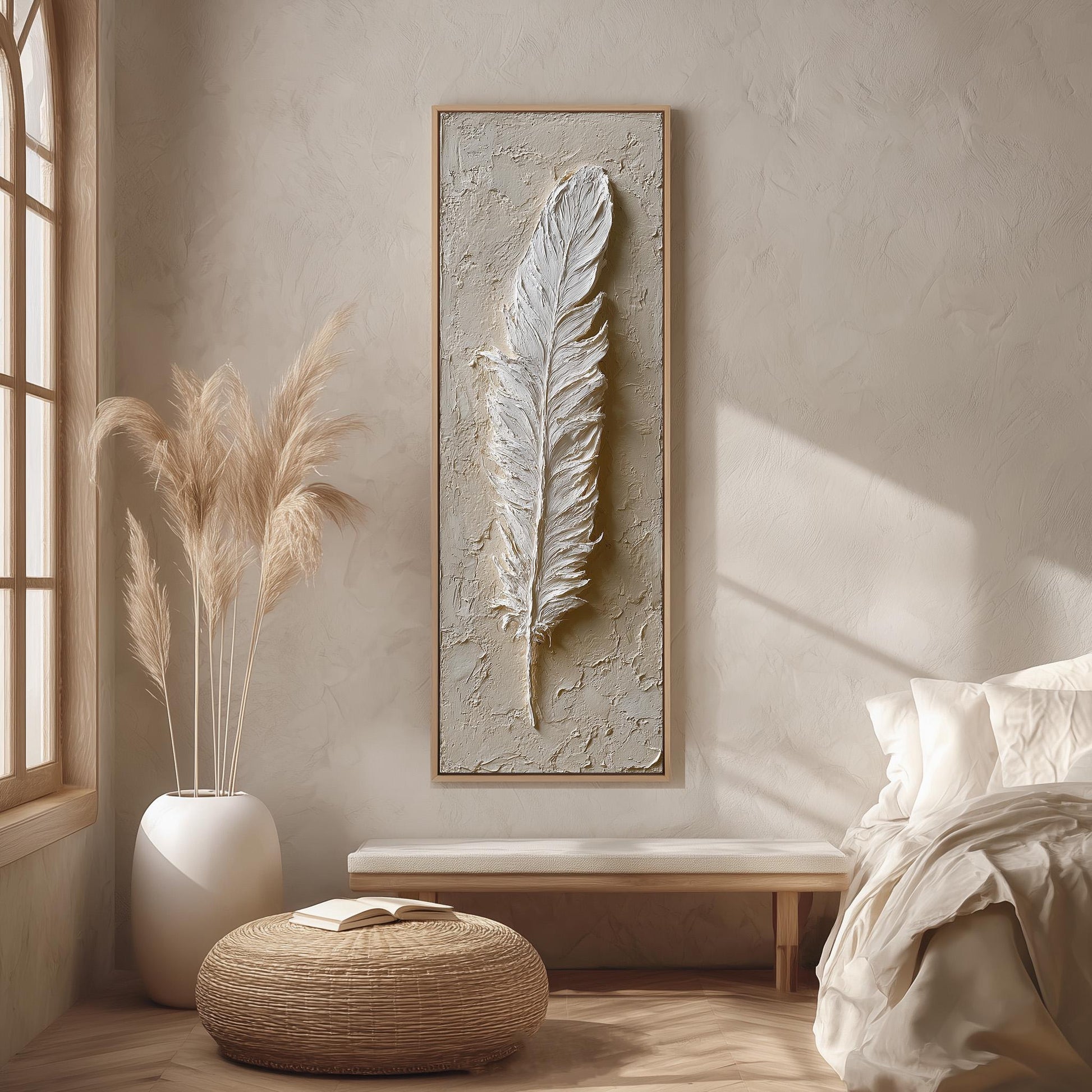 a serene and minimalist bedroom interior with a large framed feather artwork hanging on the wall, a white bed with a white pillow, a white wicker ottoman, and a potted plant.