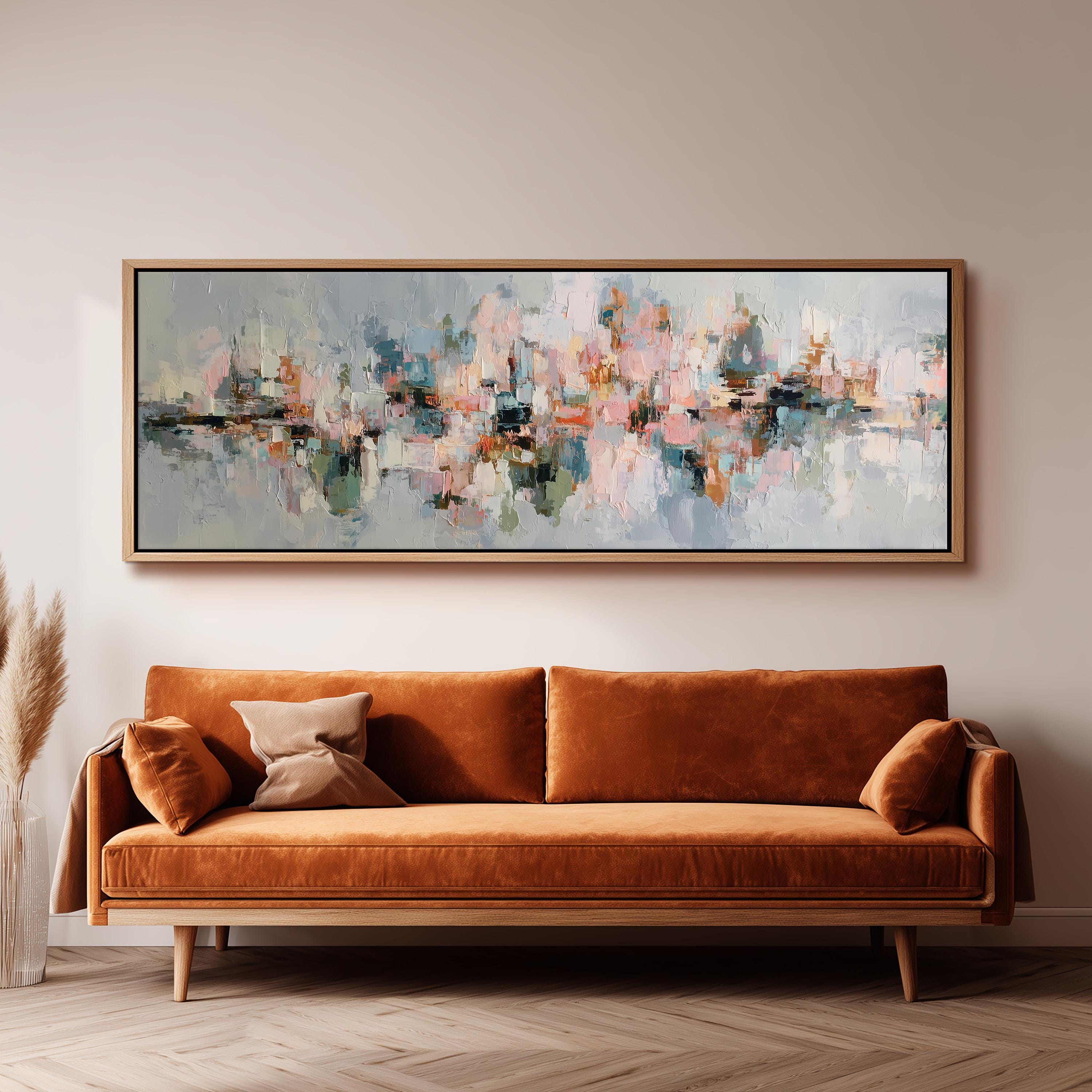 a large abstract painting hanging on a wall above a brown sofa with two pillows.
