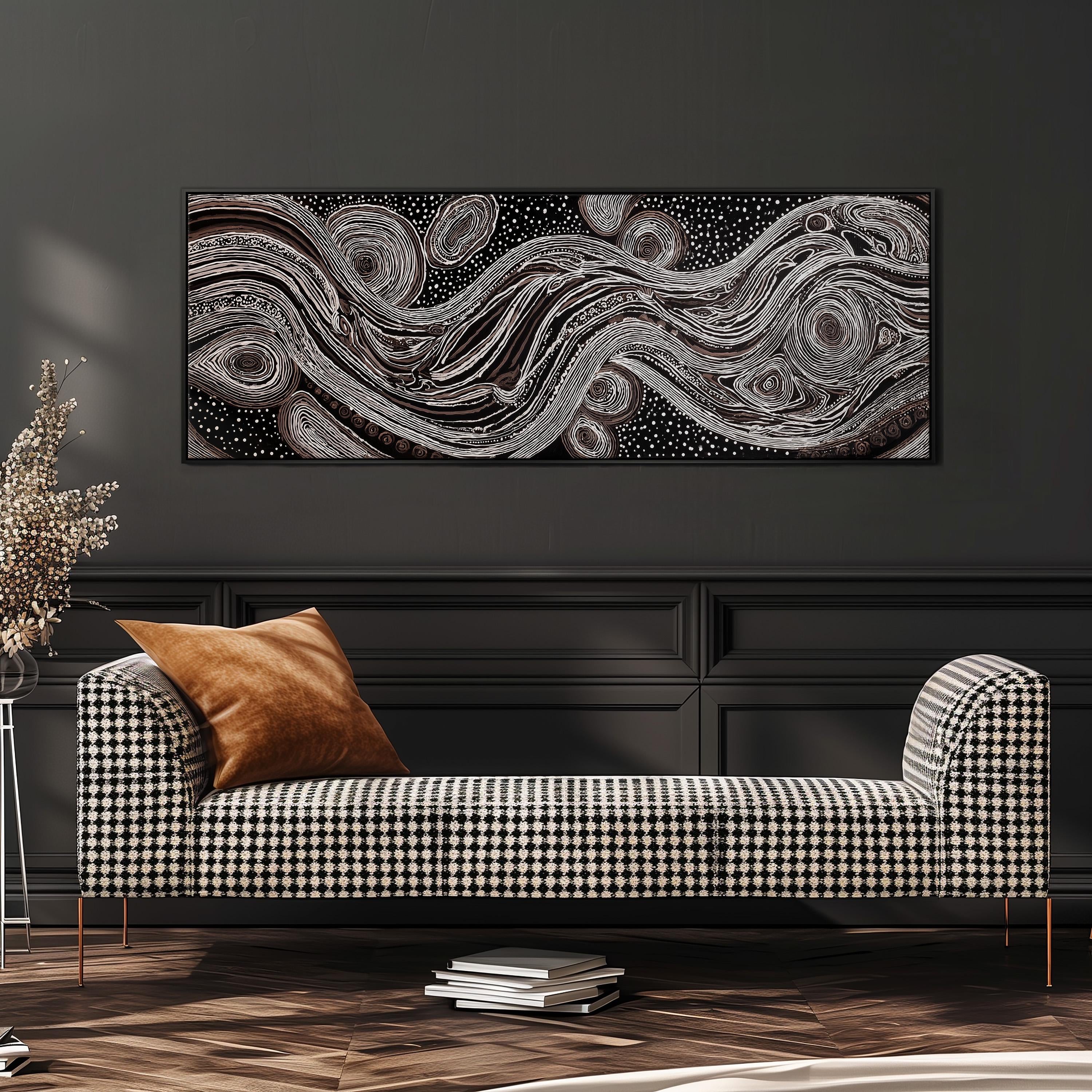 a modern living room with a black and white checkered sofa, a stack of books, and a large abstract painting hanging on the wall above the sofa.