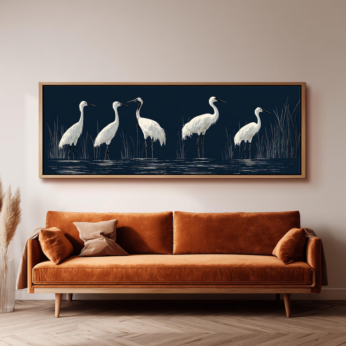 White cranes wading in a navy marsh long horizontal canvas print above a sofa in a living room