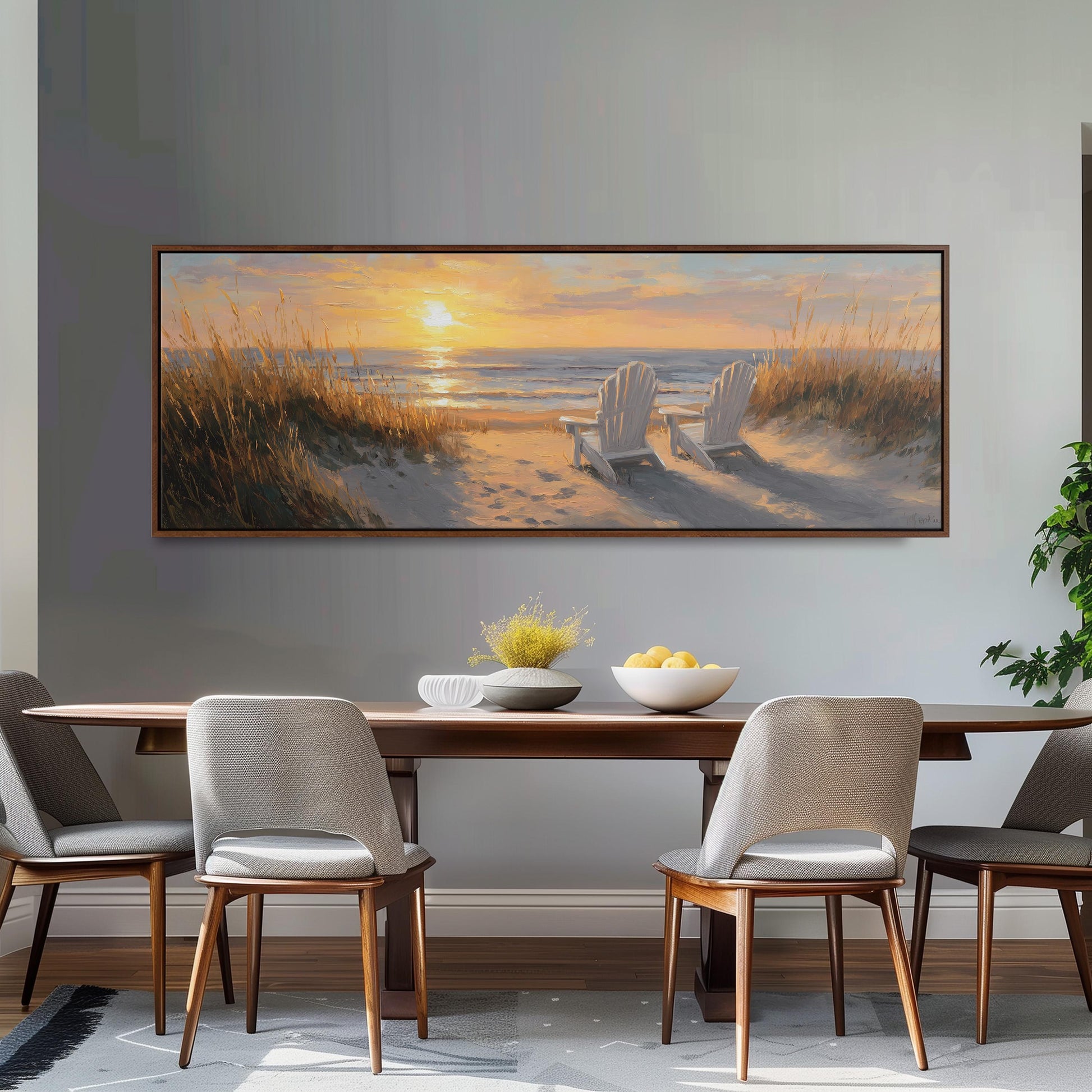 a dining room with a large painting of a beach scene hanging on the wall above a wooden dining table with four chairs. The painting depicts a serene beach scene with a sunset, grassy dunes, and a body of water.