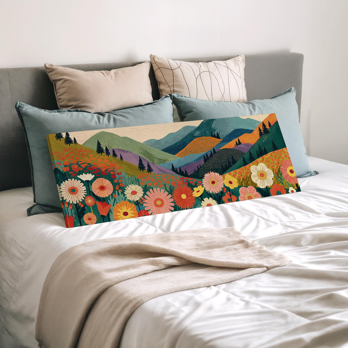 Wildflower valley below patterned mountains wide panoramic canvas print laid on a bed to show its size