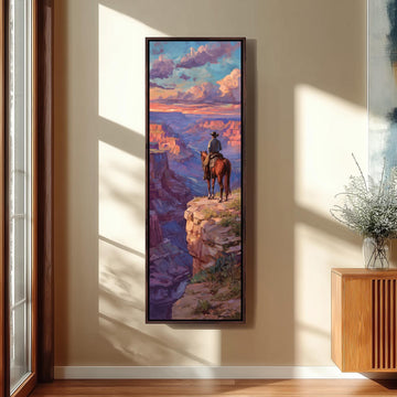 a large framed painting of a cowboy on a horse overlooking a scenic landscape, with a dramatic sky and clouds in the background.
