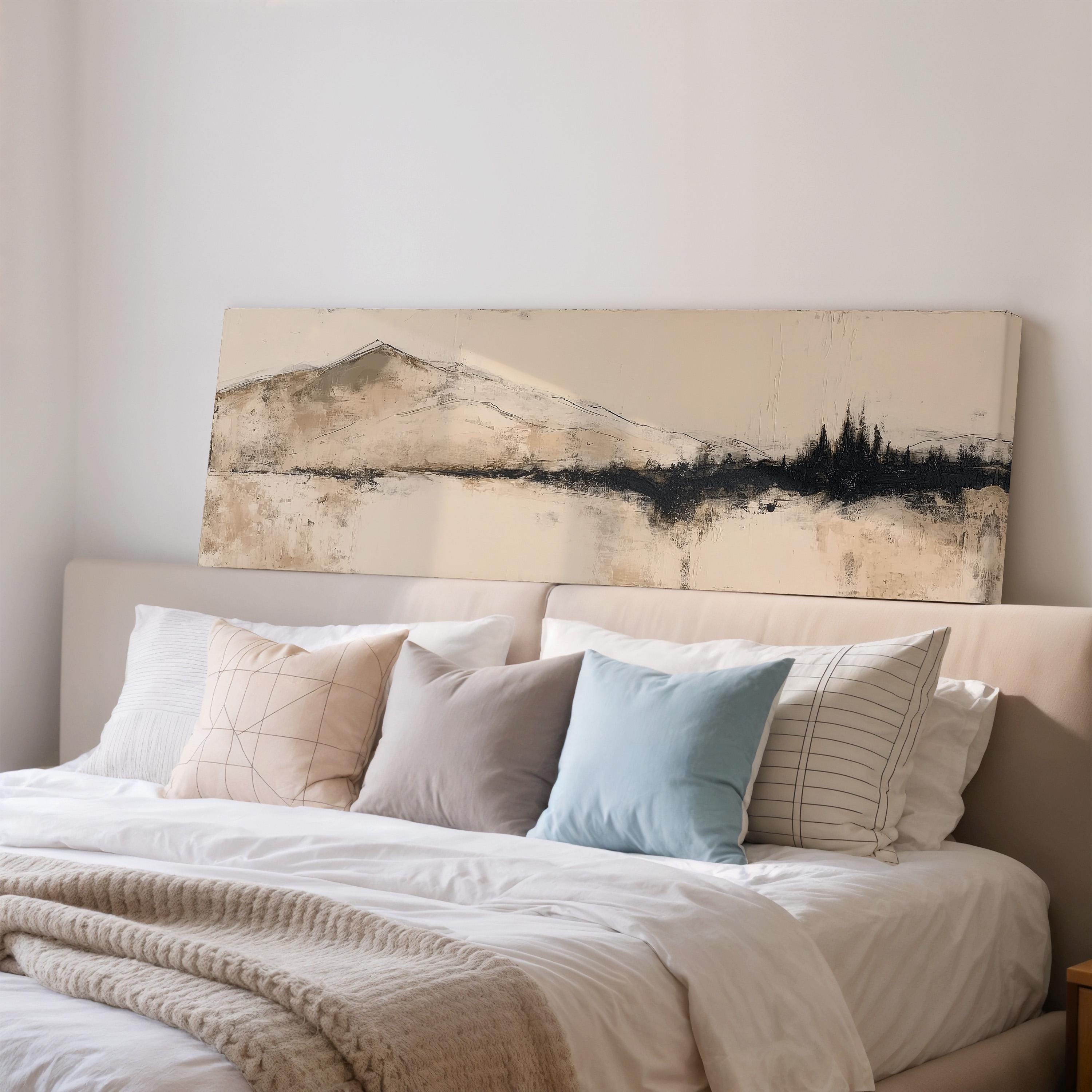 a cozy bedroom with a large bed adorned with white linens and a variety of colorful throw pillows. Above the bed, there is a large canvas print depicting a serene landscape with mountains and trees.