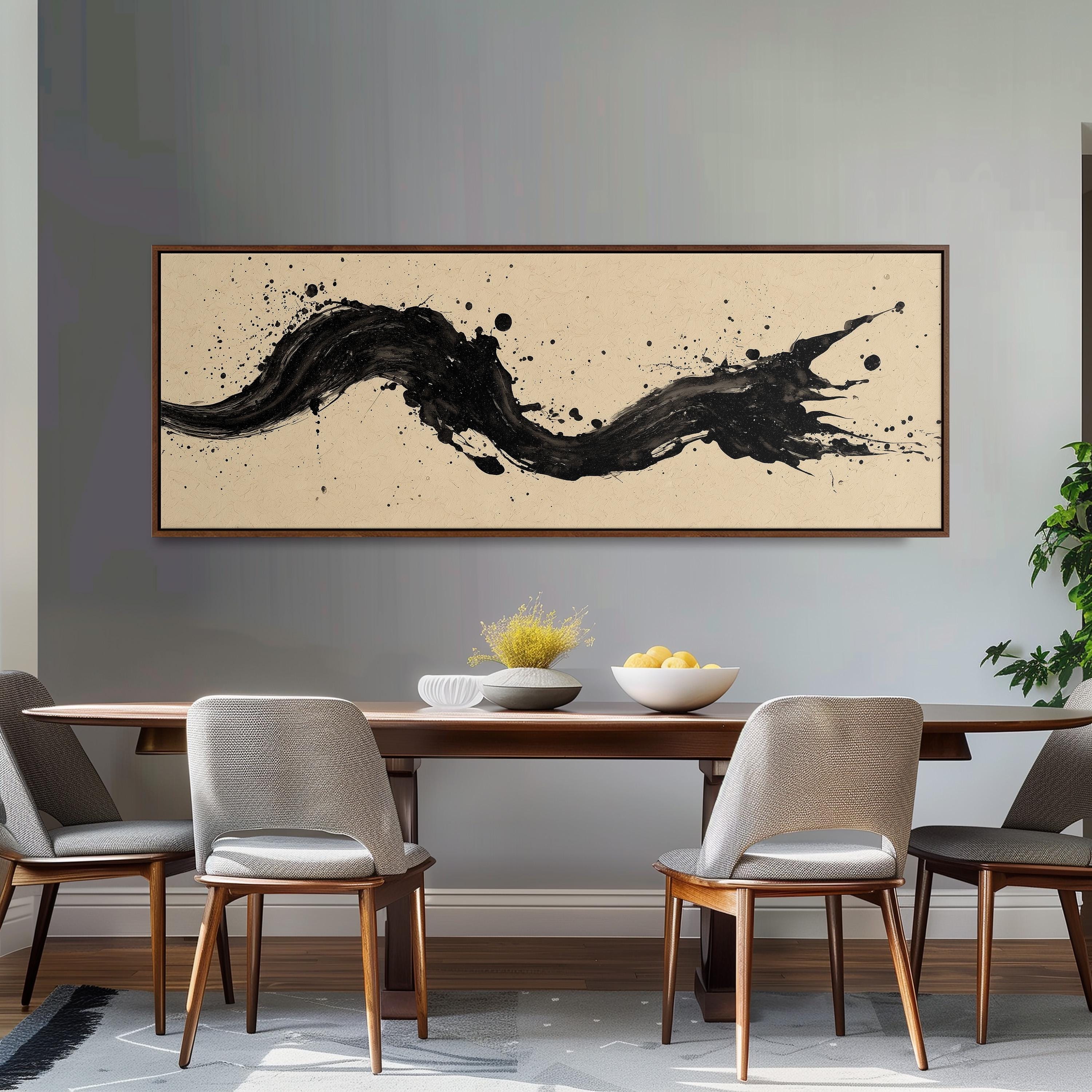 a dining room with a wooden table and four chairs. Above the table, there is a large black and white abstract painting hanging on the wall. The table is set with a bowl of fruit and a vase of flowers, creating a cozy and inviting atmosphere.