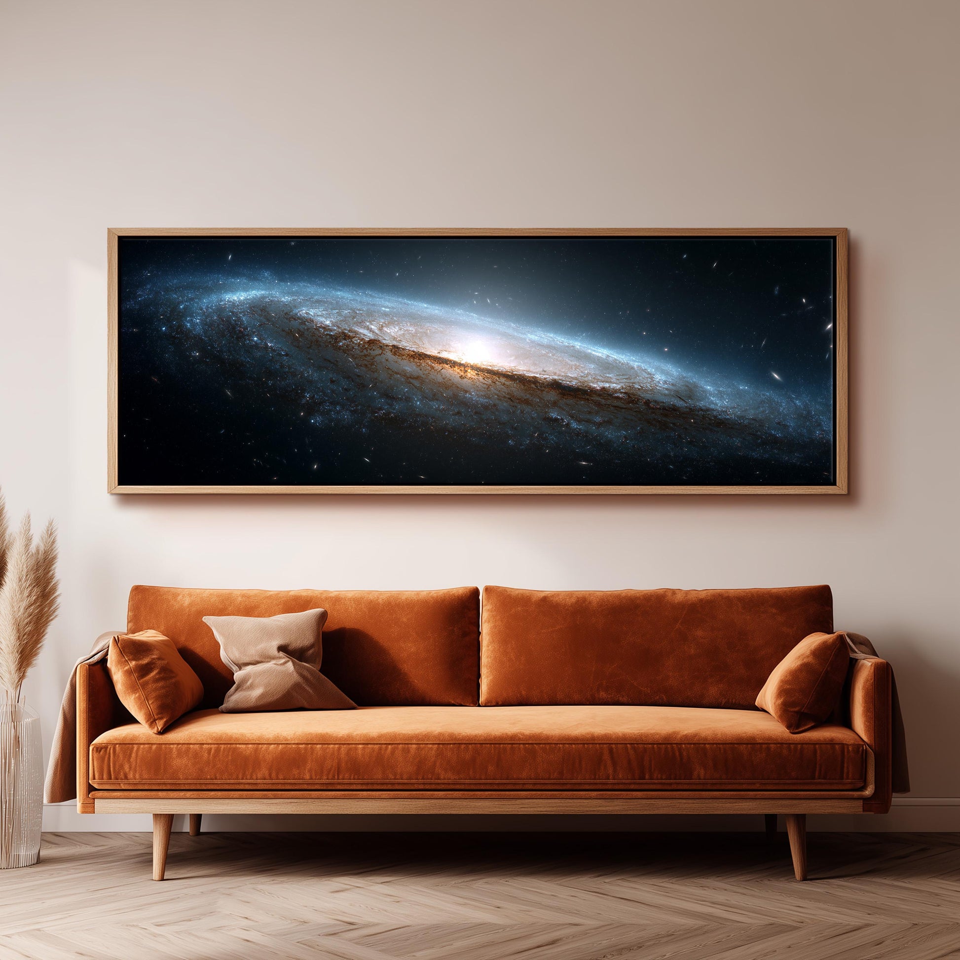 a large, framed picture of a galaxy hanging on a wall above a brown sofa.