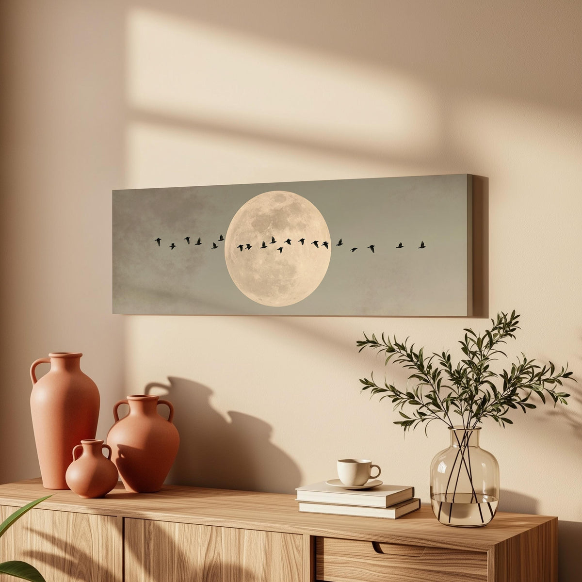 Geese crossing a full moon on grey long horizontal canvas print above a wooden sideboard