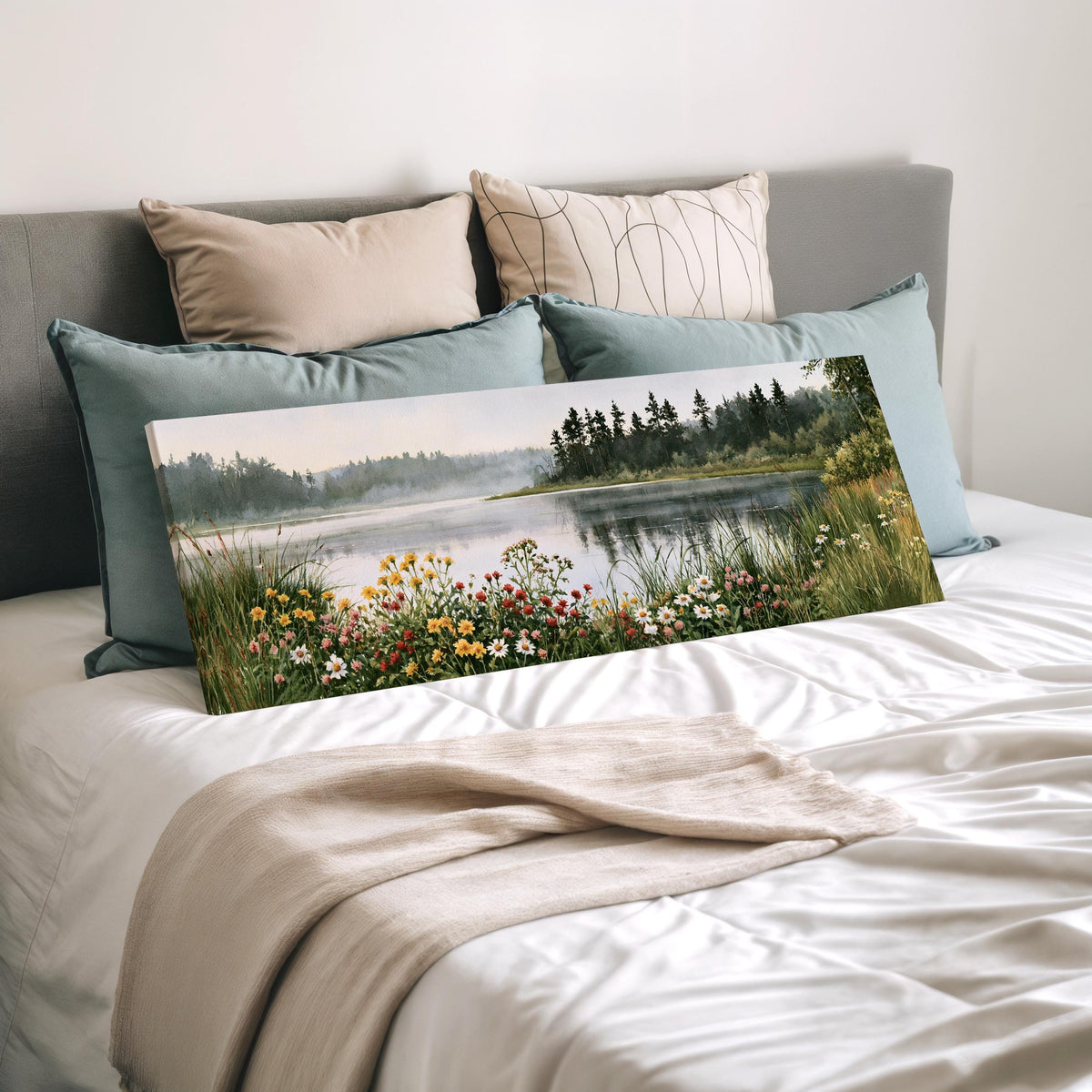 Lake with wildflowers on the shore wide panoramic canvas print laid on a bed to show its size