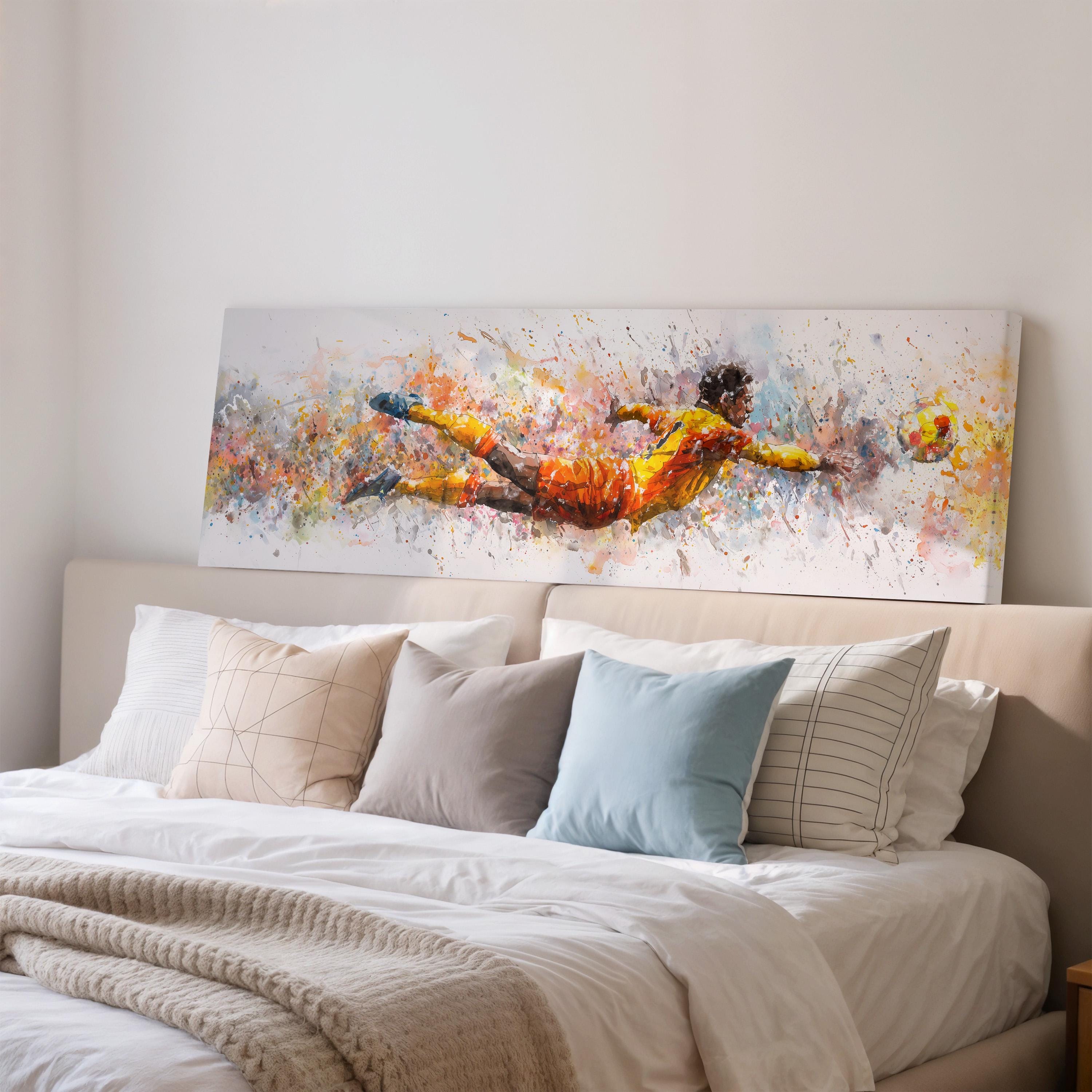 a large, colorful painting of a soccer player in mid-air, with splashes of color and dynamic brushstrokes, displayed on a wall above a bed with white bedding and pillows.