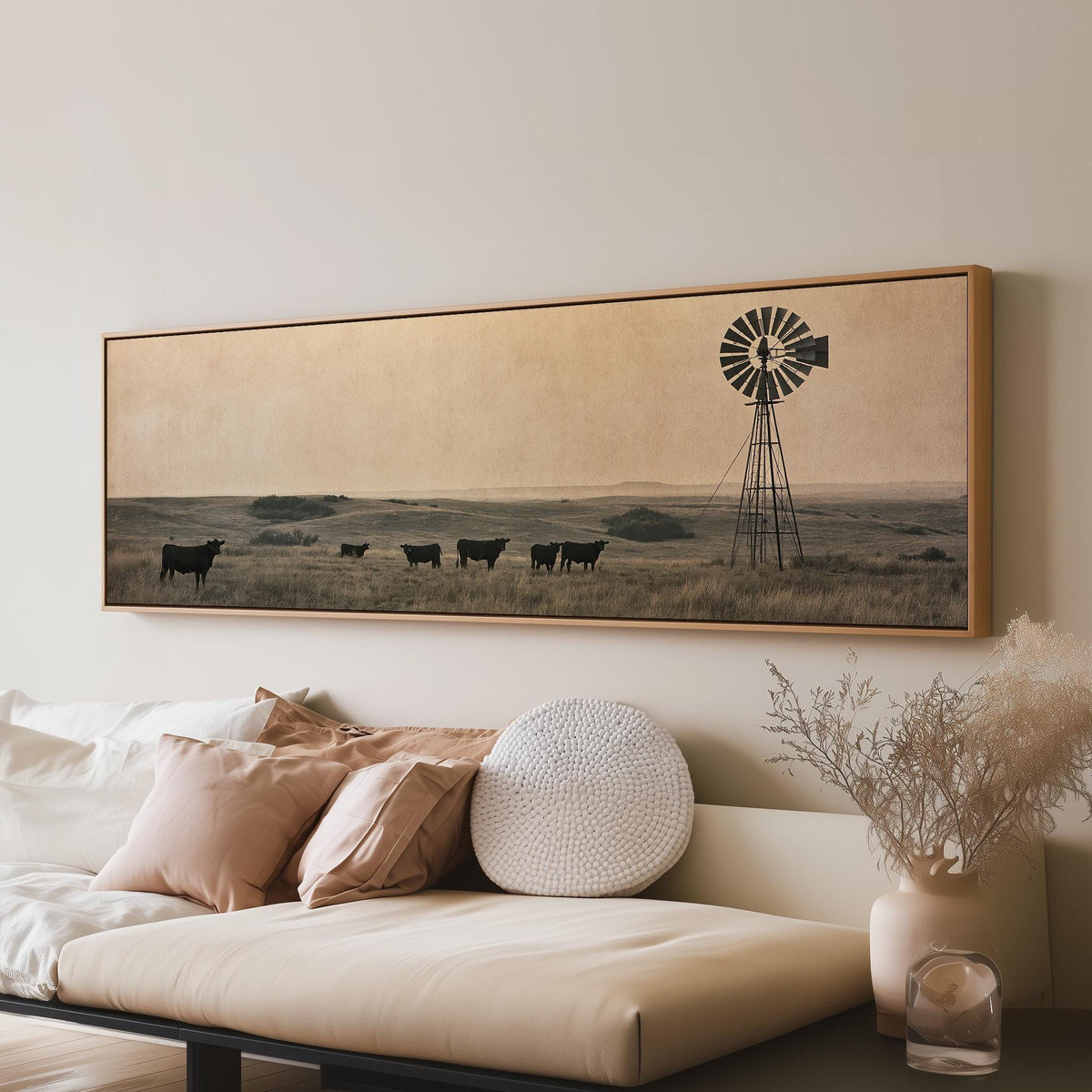 Black cattle grazing by a windmill on the prairie long horizontal canvas print above a sofa in a living room