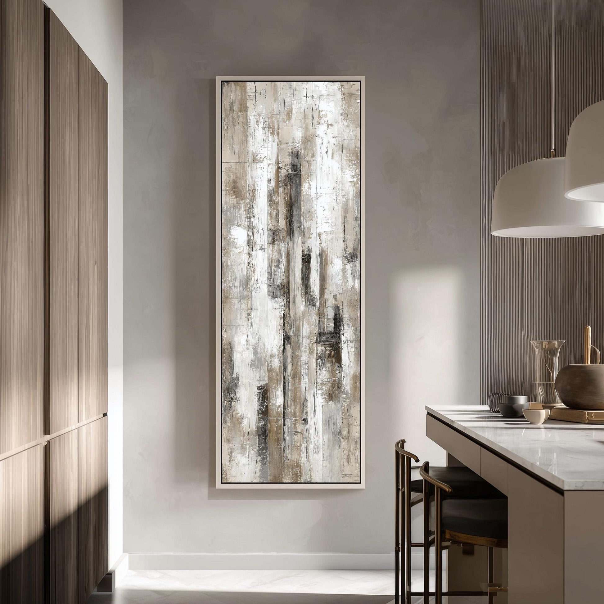 a modern kitchen with a large abstract painting hanging on the wall above a counter. The painting has a textured, white and gray color scheme, and it appears to be a large canvas. The kitchen has a clean, minimalist design with white cabinets and a marble countertop. There are two chairs in the kitchen, one near the counter and another closer to the painting.