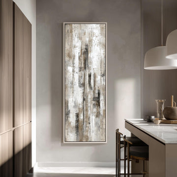 a modern kitchen with a large abstract painting hanging on the wall above a counter. The painting has a textured, white and gray color scheme, and it appears to be a large canvas. The kitchen has a clean, minimalist design with white cabinets and a marble countertop. There are two chairs in the kitchen, one near the counter and another closer to the painting.