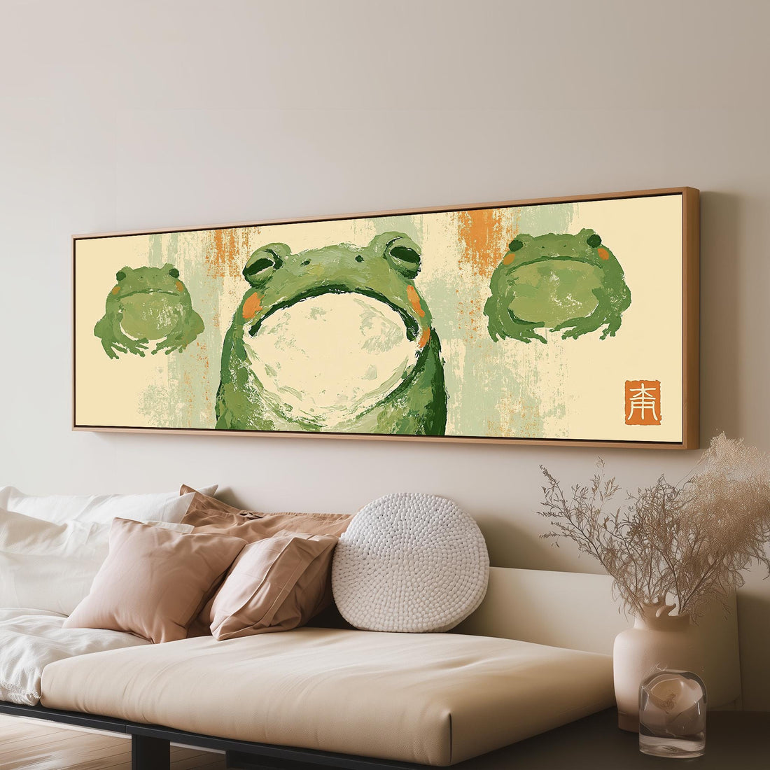 Three zen frogs in a sumi-e style long horizontal canvas print above a sofa in a living room