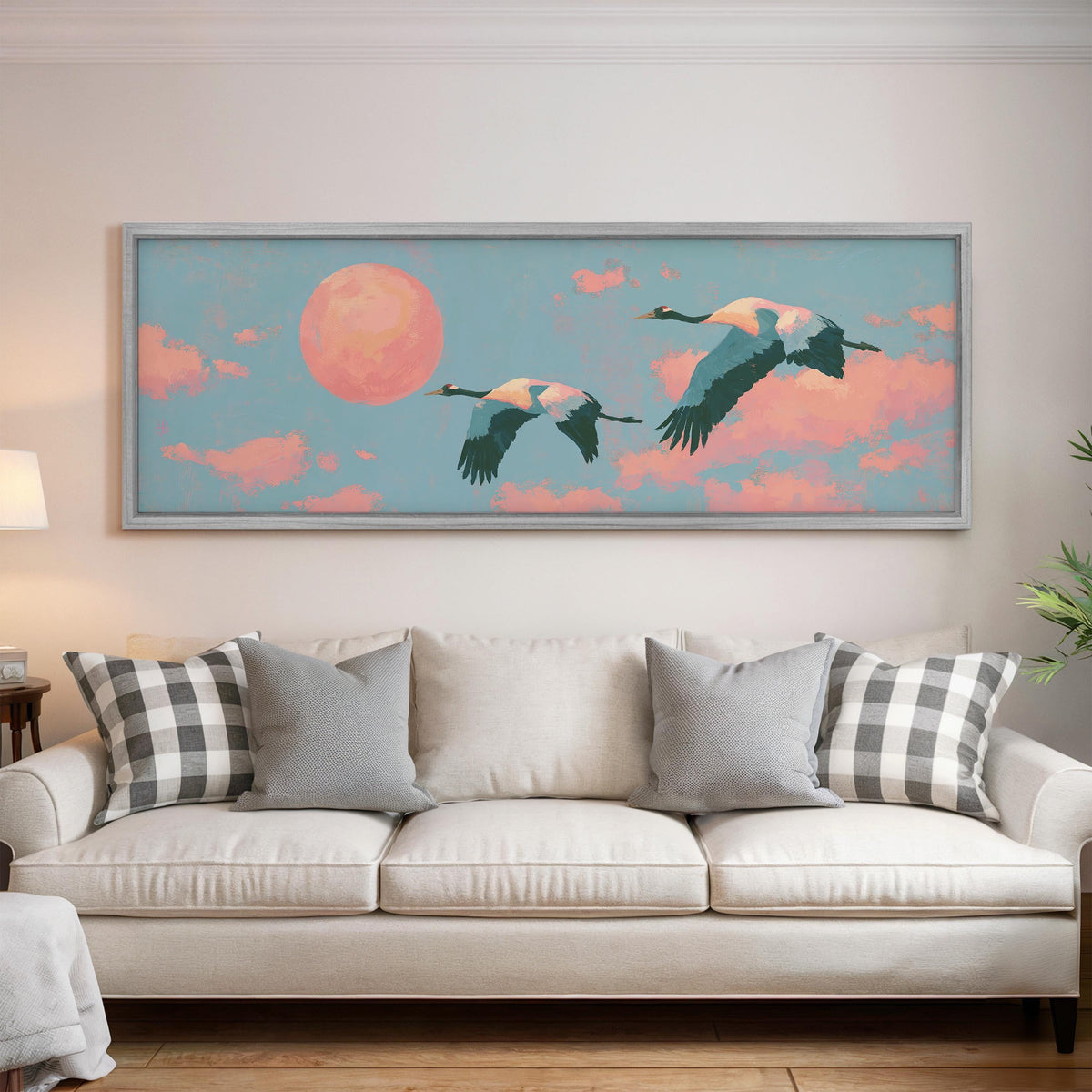 Two cranes flying at sunset panoramic canvas print above a white sofa in a bright living room