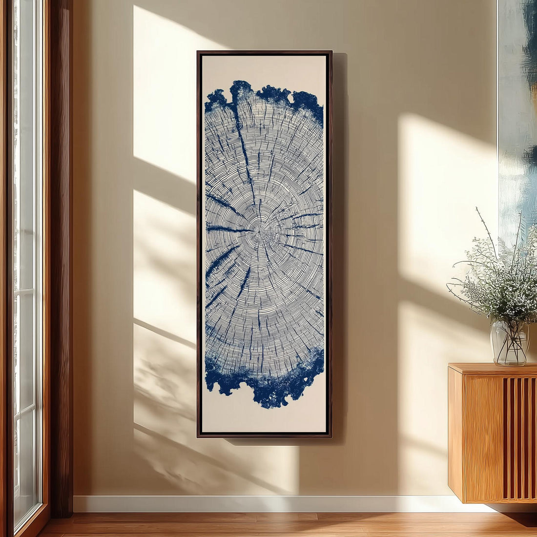 a large framed artwork hanging on a wall, depicting a tree stump with a blue and white color scheme.