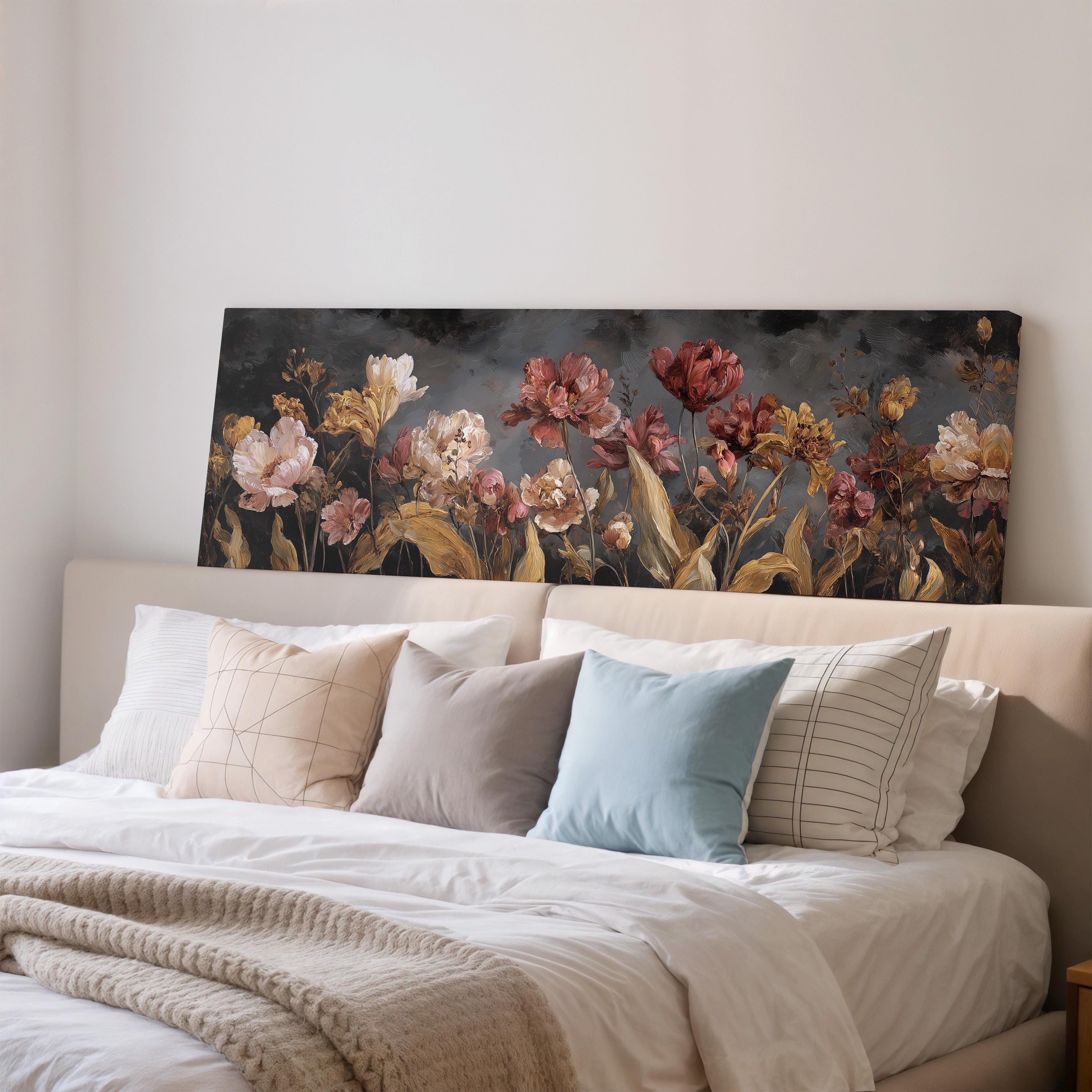 a large floral painting hanging on a wall above a bed with white bedding and pillows.