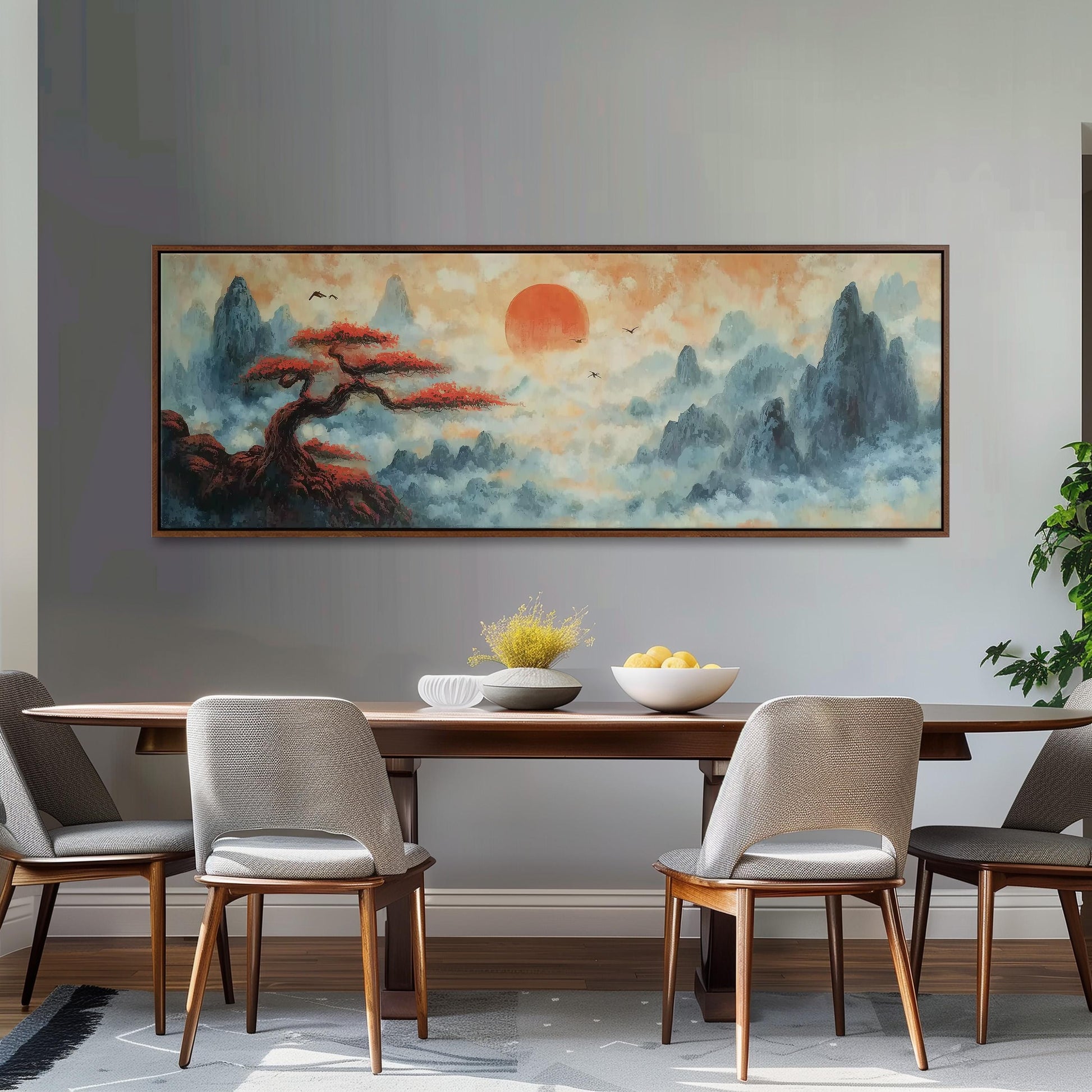 a dining room with a large painting of a landscape hanging on the wall above a wooden table with four chairs. The painting depicts a serene mountain landscape with a tree and a sun in the sky.