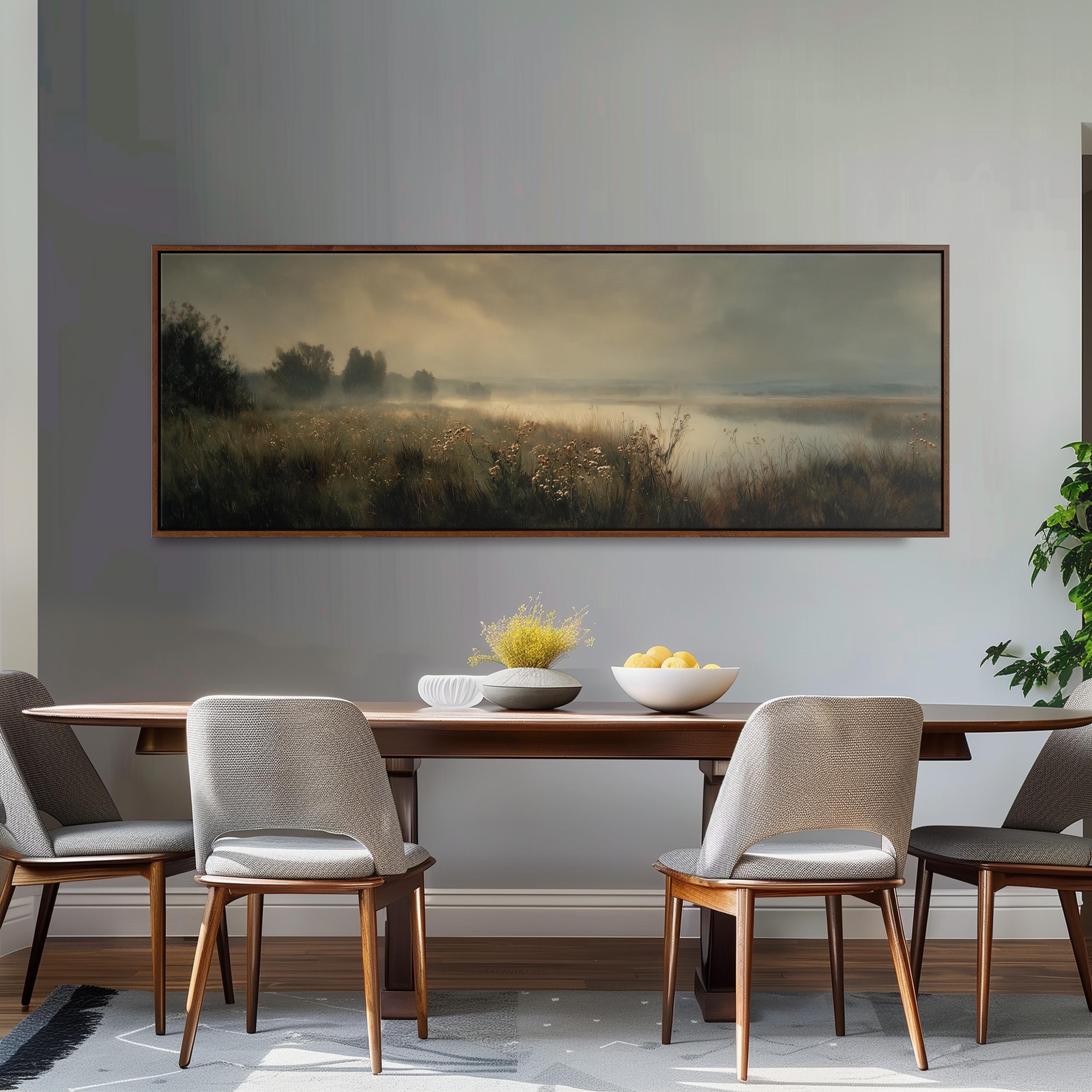 a dining room with a large painting of a field hanging on the wall above a wooden dining table with four chairs. The table is set with a bowl of fruit and a vase of flowers, creating a cozy and inviting atmosphere.