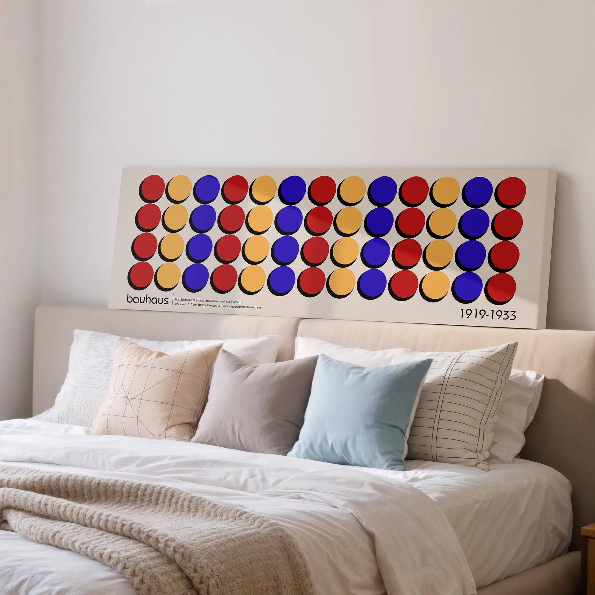 a large, colorful abstract painting hanging on a wall above a bed with white bedding.