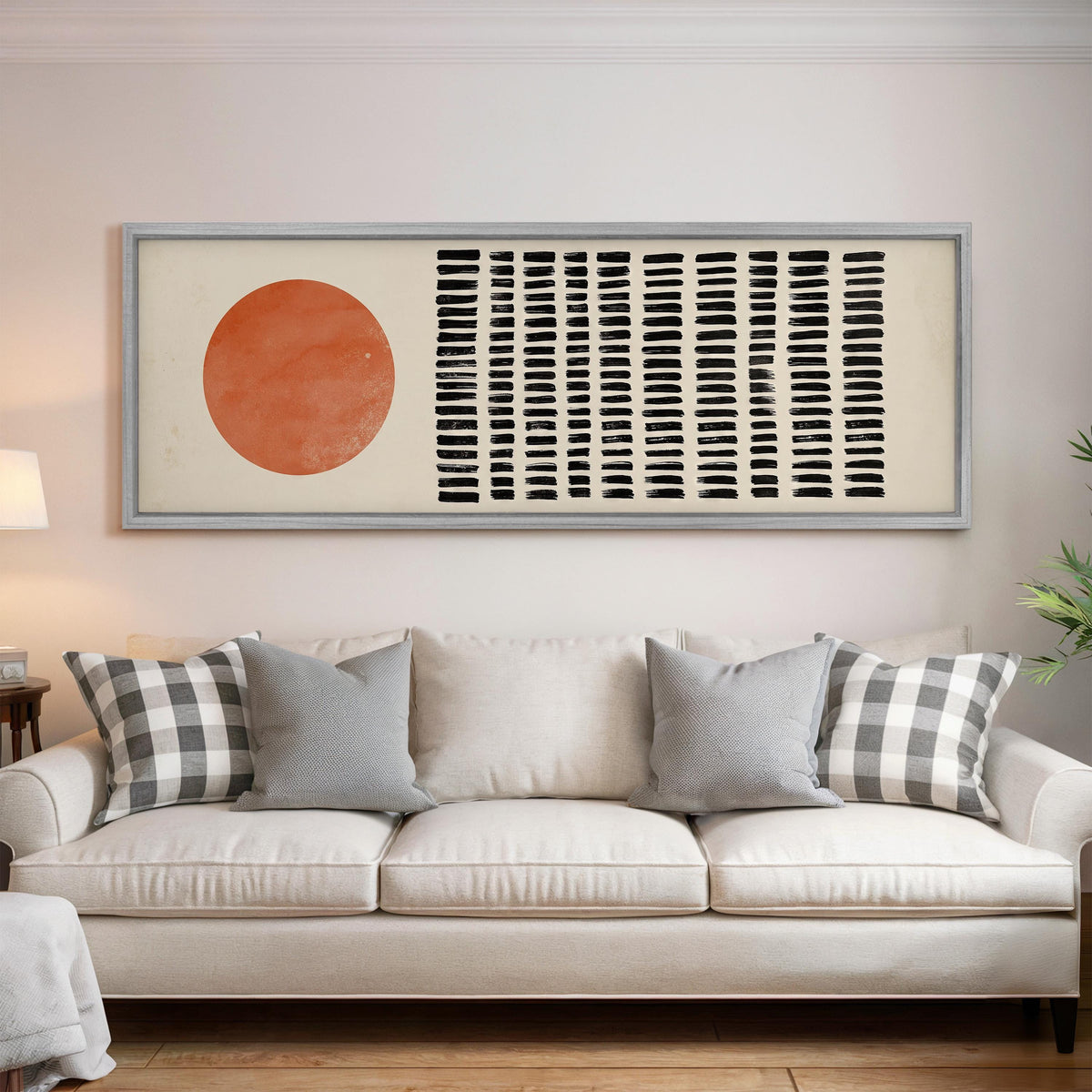 Orange sun beside rows of black dashes panoramic canvas print above a white sofa in a bright living room