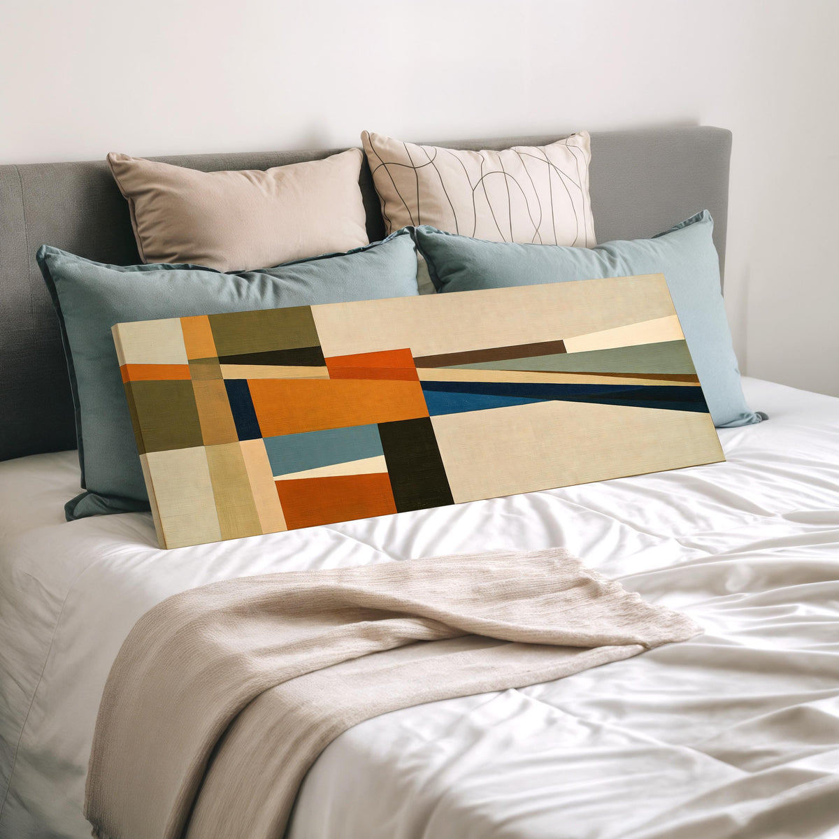 Olive and rust geometric blocks wide panoramic canvas print laid on a bed to show its size