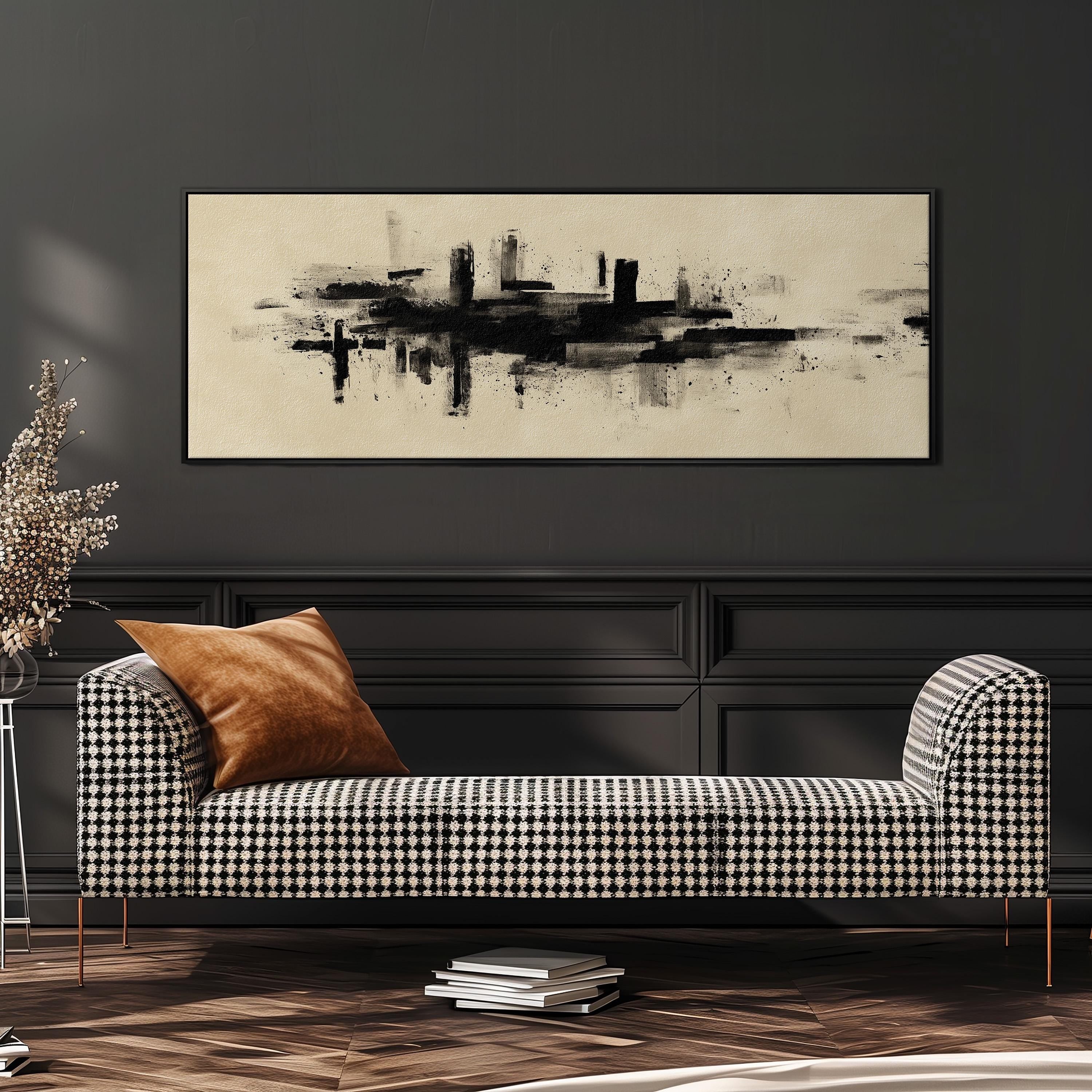 a modern living room with a black and white checkered sofa, a large abstract painting on the wall, and a stack of books on the floor.