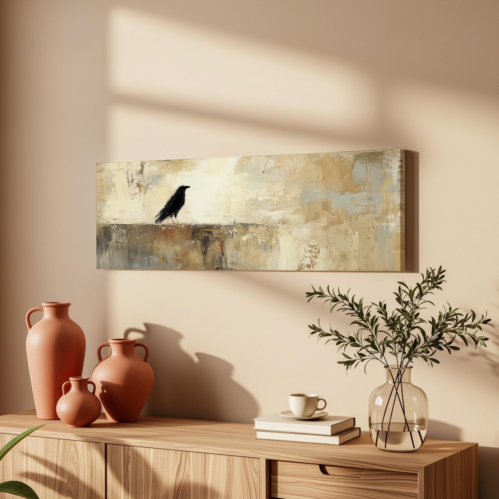 a wooden cabinet with a painting of a black bird on the wall above it, along with three orange vases and a glass vase with greenery.