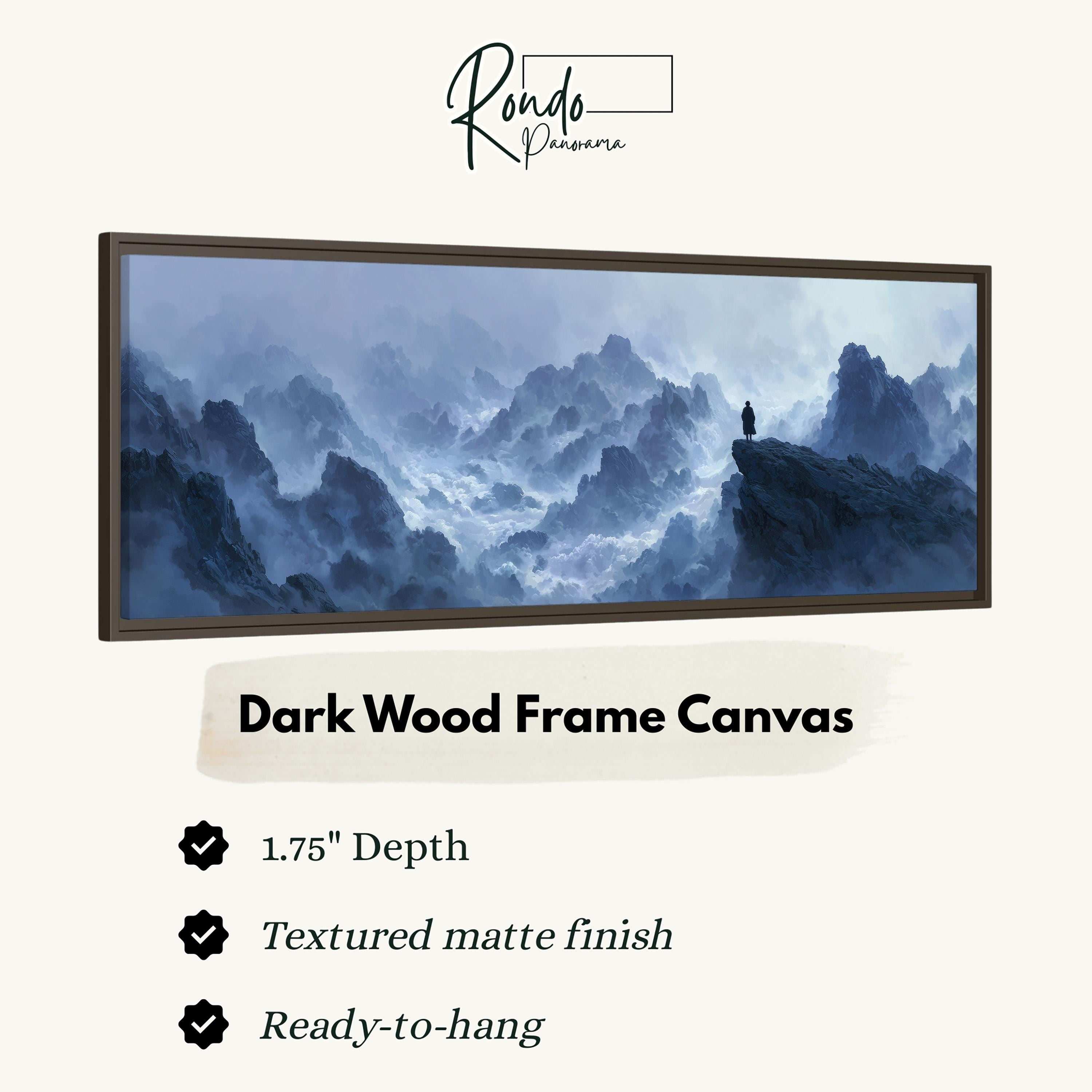 The image is a dark wood frame canvas depicting a mountainous landscape with a lone figure standing on a cliff.