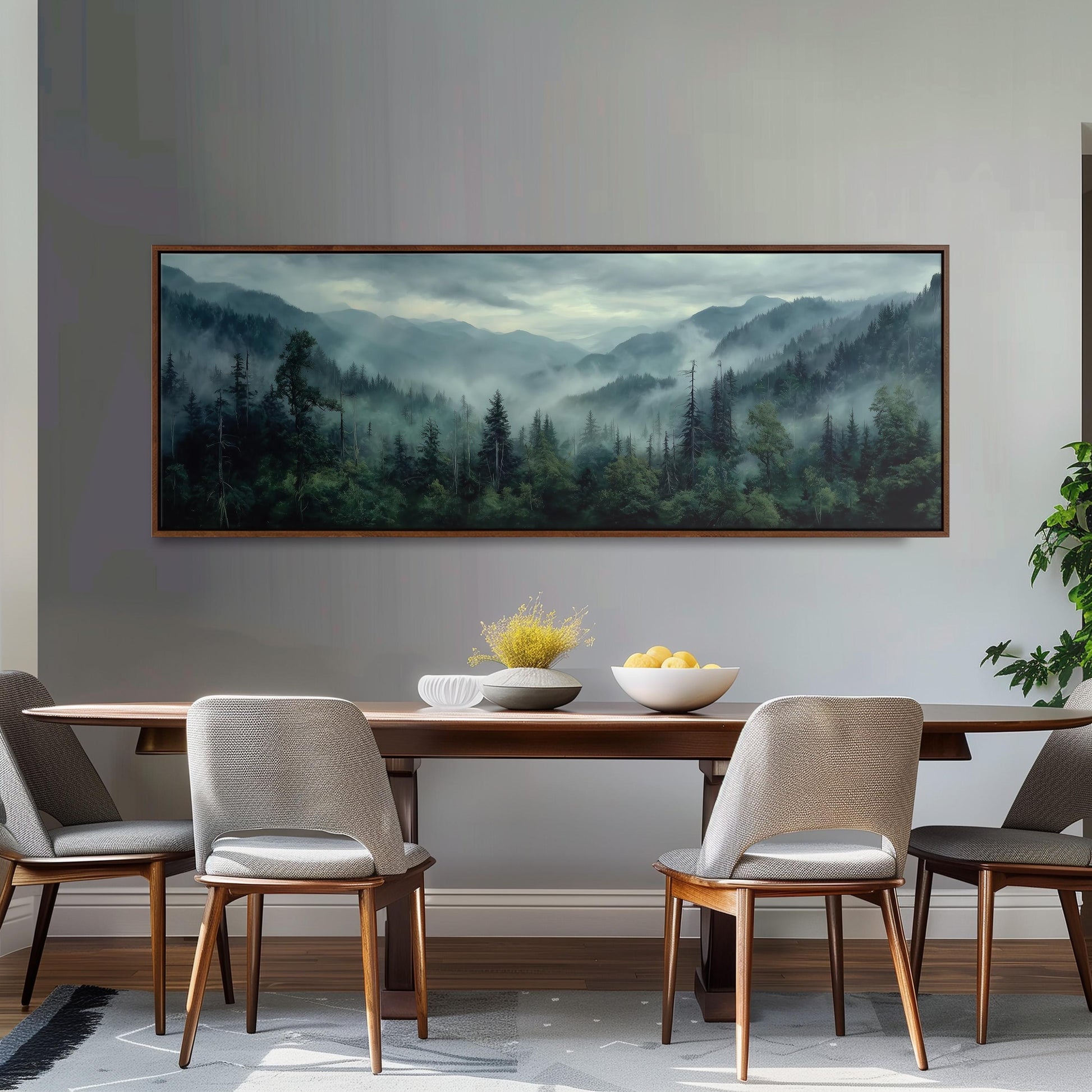 a dining room with a large painting of a forest landscape hanging on the wall above a wooden dining table with four chairs. The table is set with a bowl of fruit and a vase of flowers, creating a cozy and inviting atmosphere.