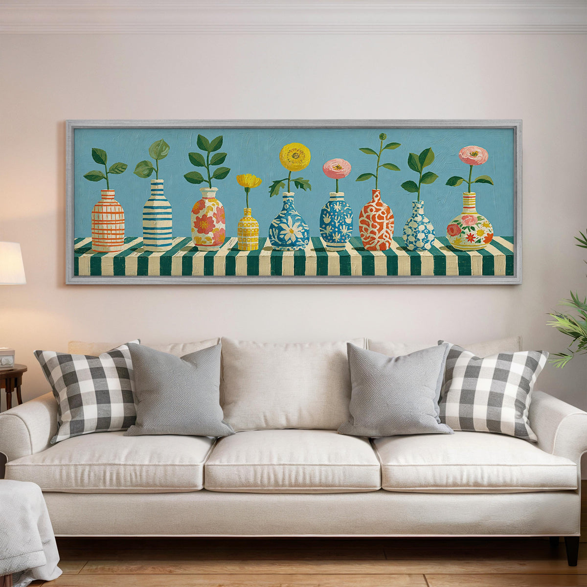 Row of striped vases with flowers panoramic canvas print above a white sofa in a bright living room